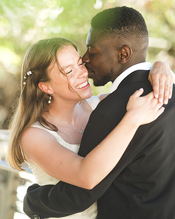 Bride and groom sharing a kiss during their elopement wedding in Indiana. Bride wearing a cream dress with jewelry, groom in a black tuxedo.