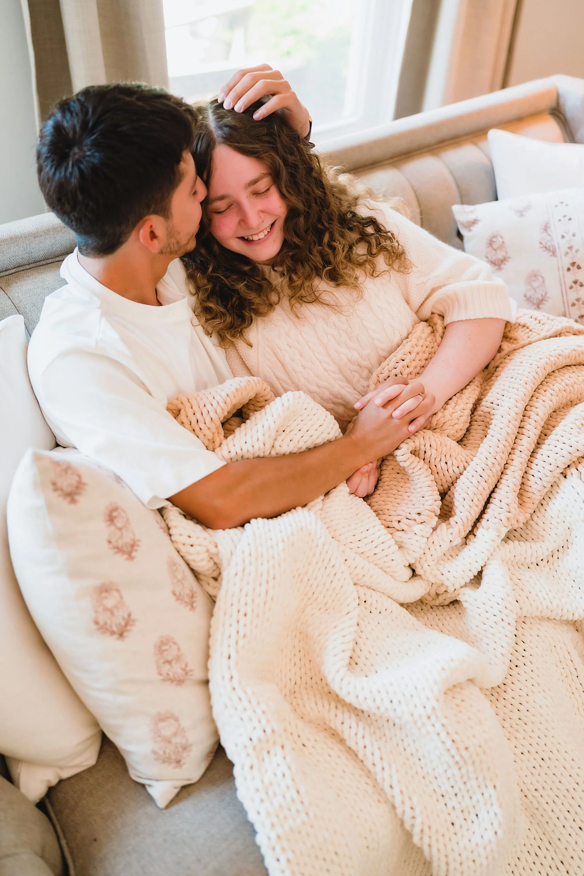 Warm in-home moment with couple wrapped in luxury knit blankets by Little Giraffe