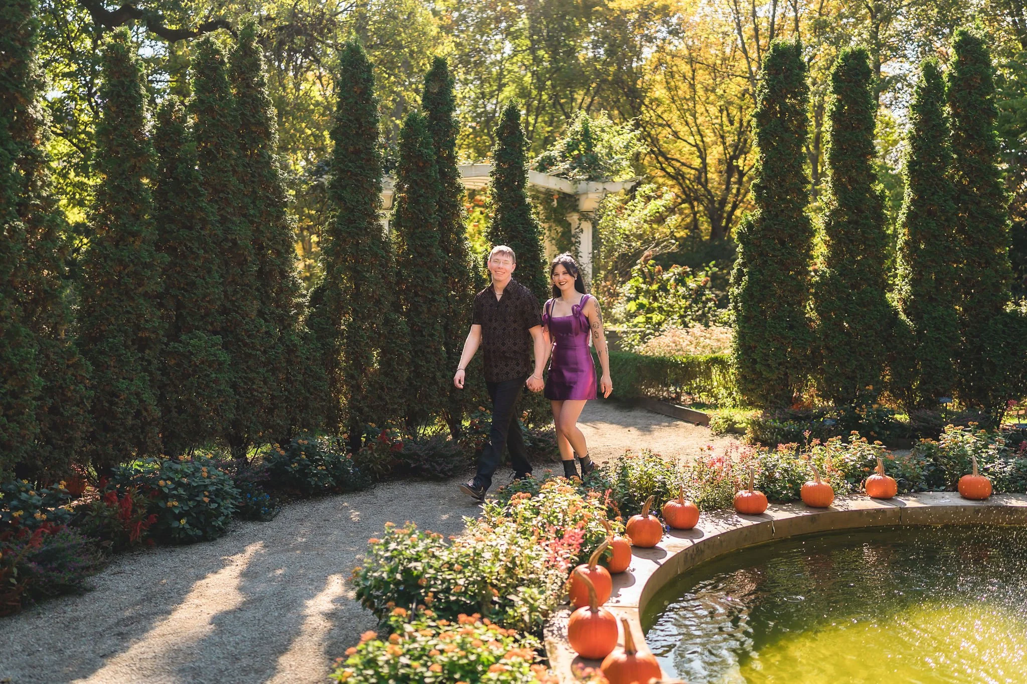 Romantic engagement photos of a couple walking together through the outdoor gardens at Newfields in Indianapolis