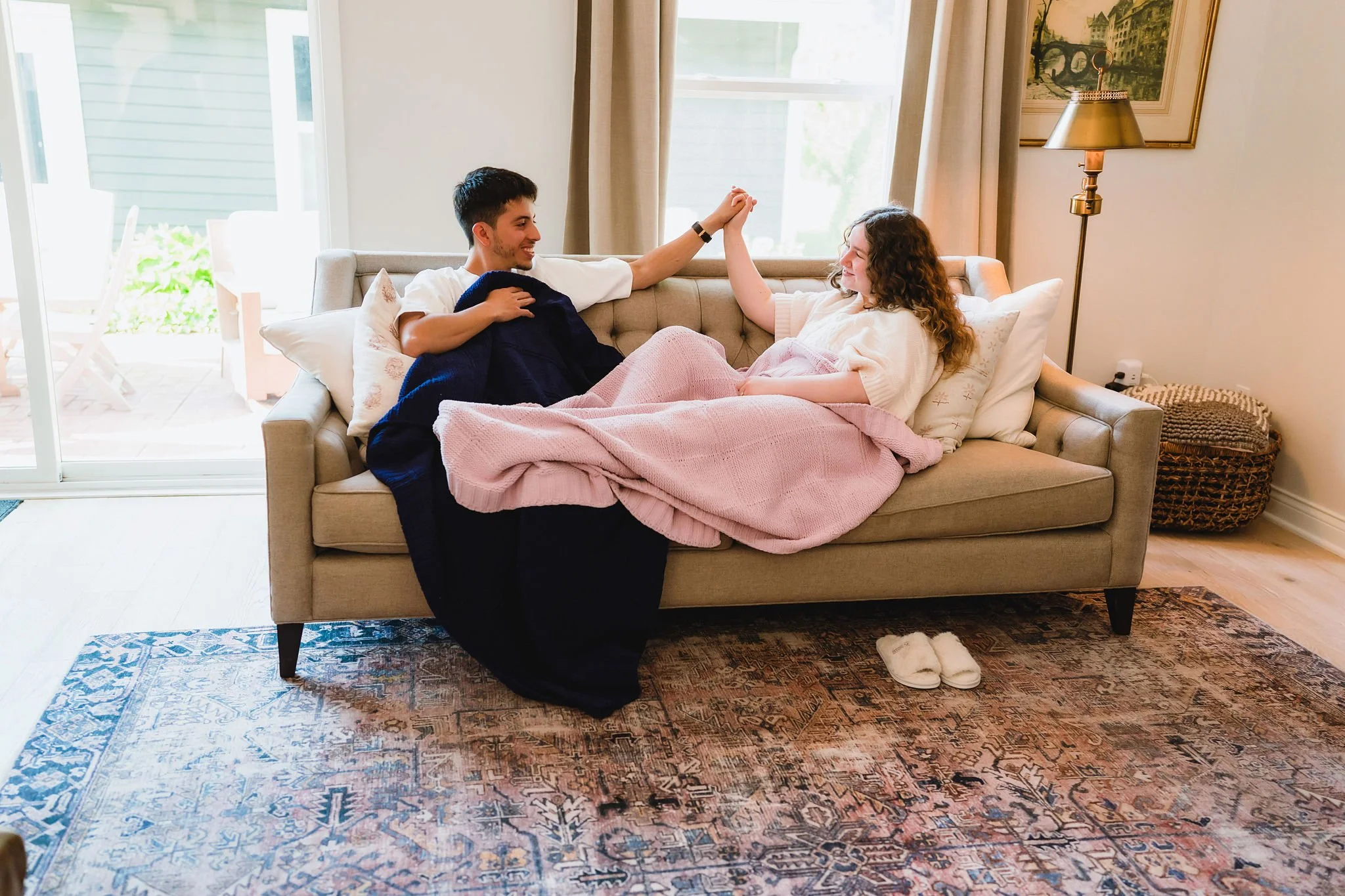 Romantic in-home moment with couple snuggled under Little Giraffe knit throw blanket