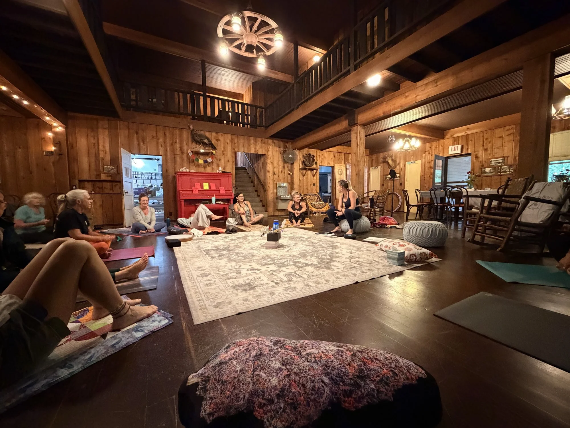 Women gathered in a circle for yoga in the great room at Fox Springs Lodge