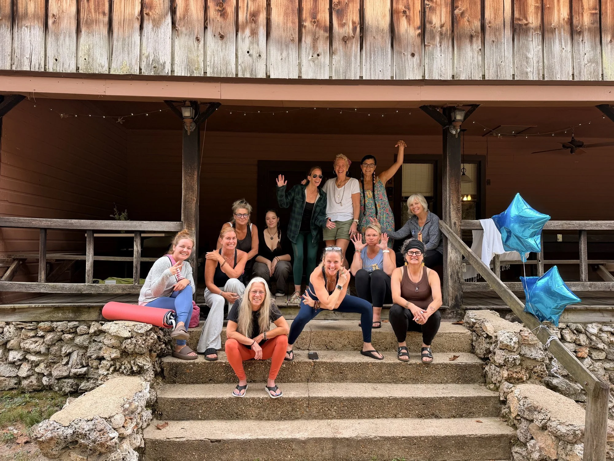 Women from the September 2026 retreat gathered on the porch steps at Fox Springs Lodge in Missouri