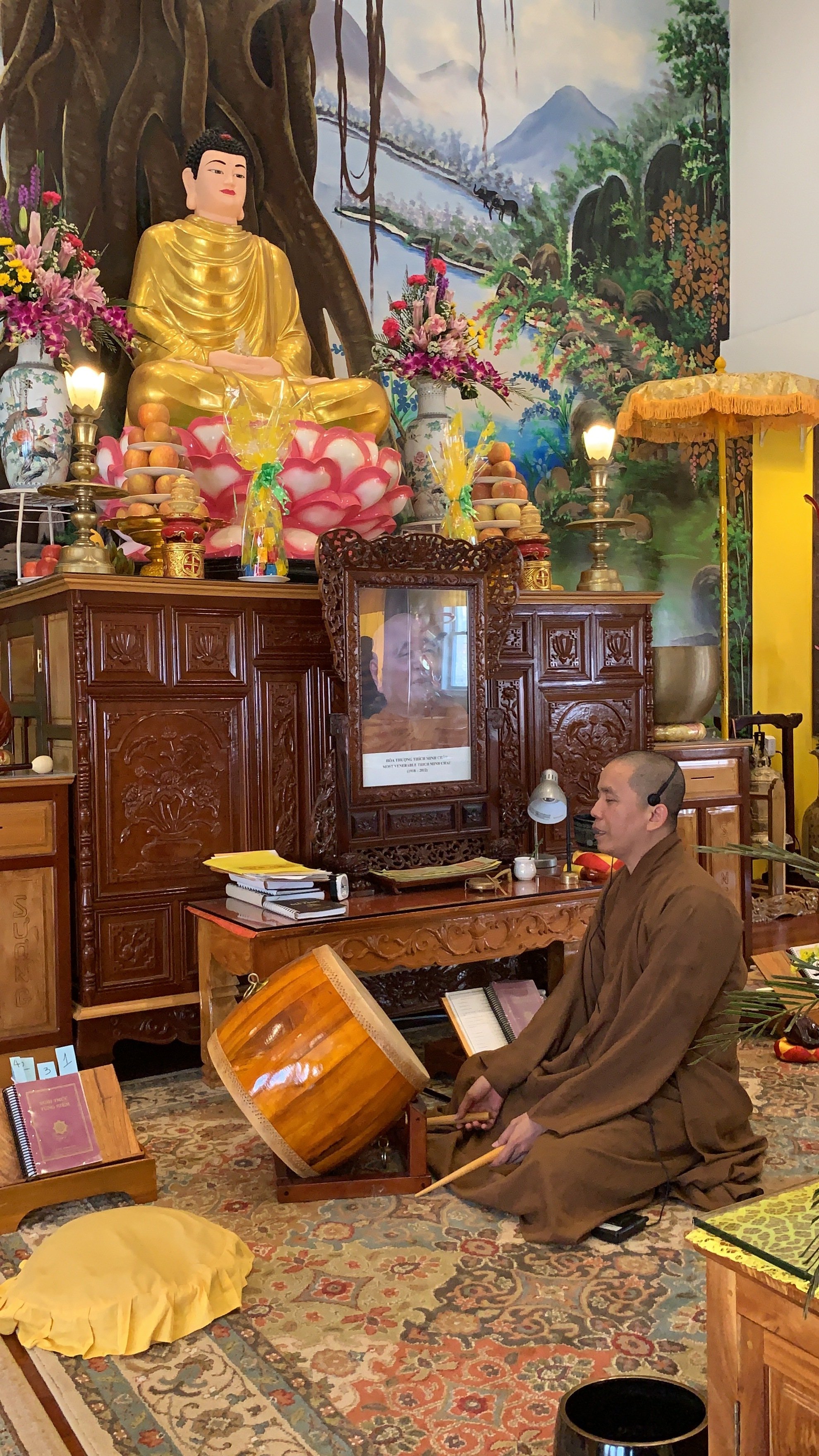 The Ven. Thích Tâm Hỷ chants beneath a statue of the Buddha at Chùa Tường Vân in Lowell.