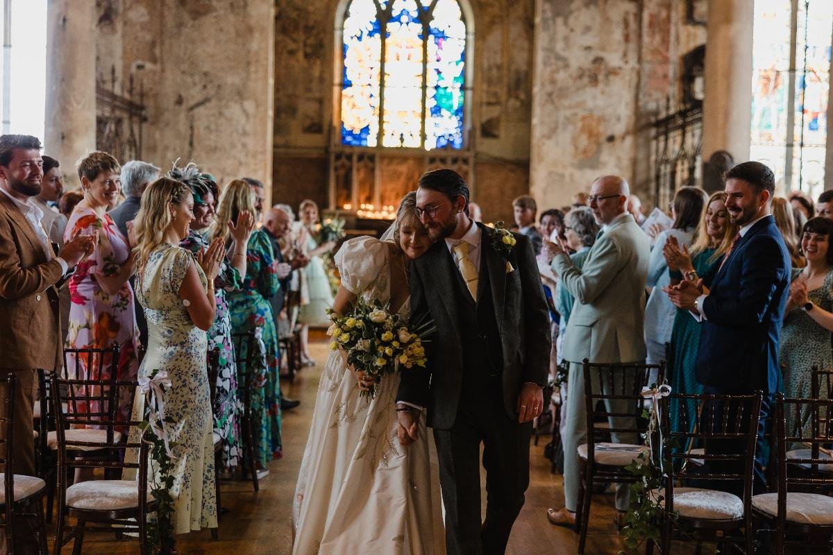 bride and groom walking back up the aisle in the mount without