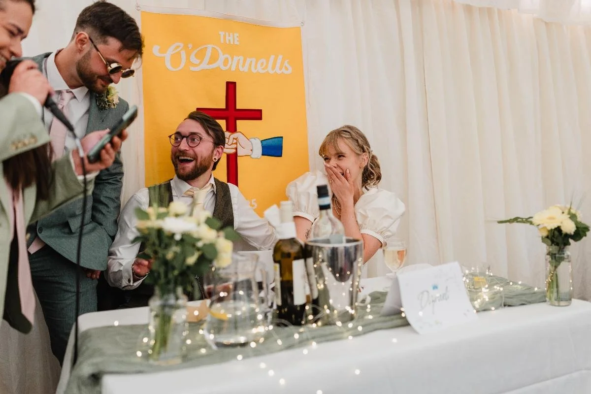 bride laughing during speeches at beeses