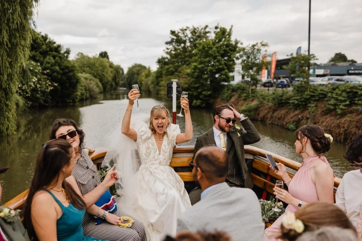 bride cheering with champagne in the air on a boat