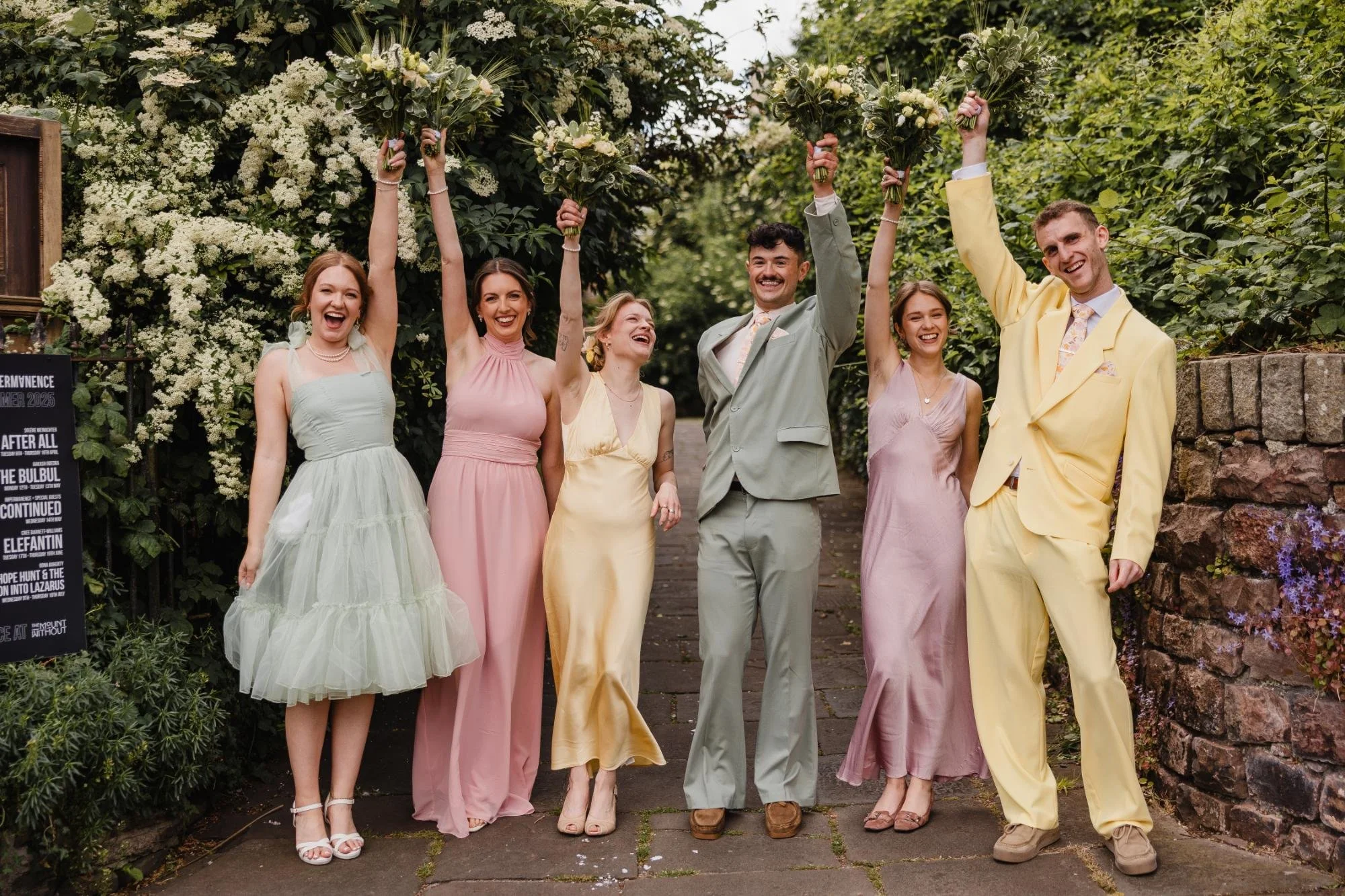 mismatched pastel wedding party outfits with bridal party cheering