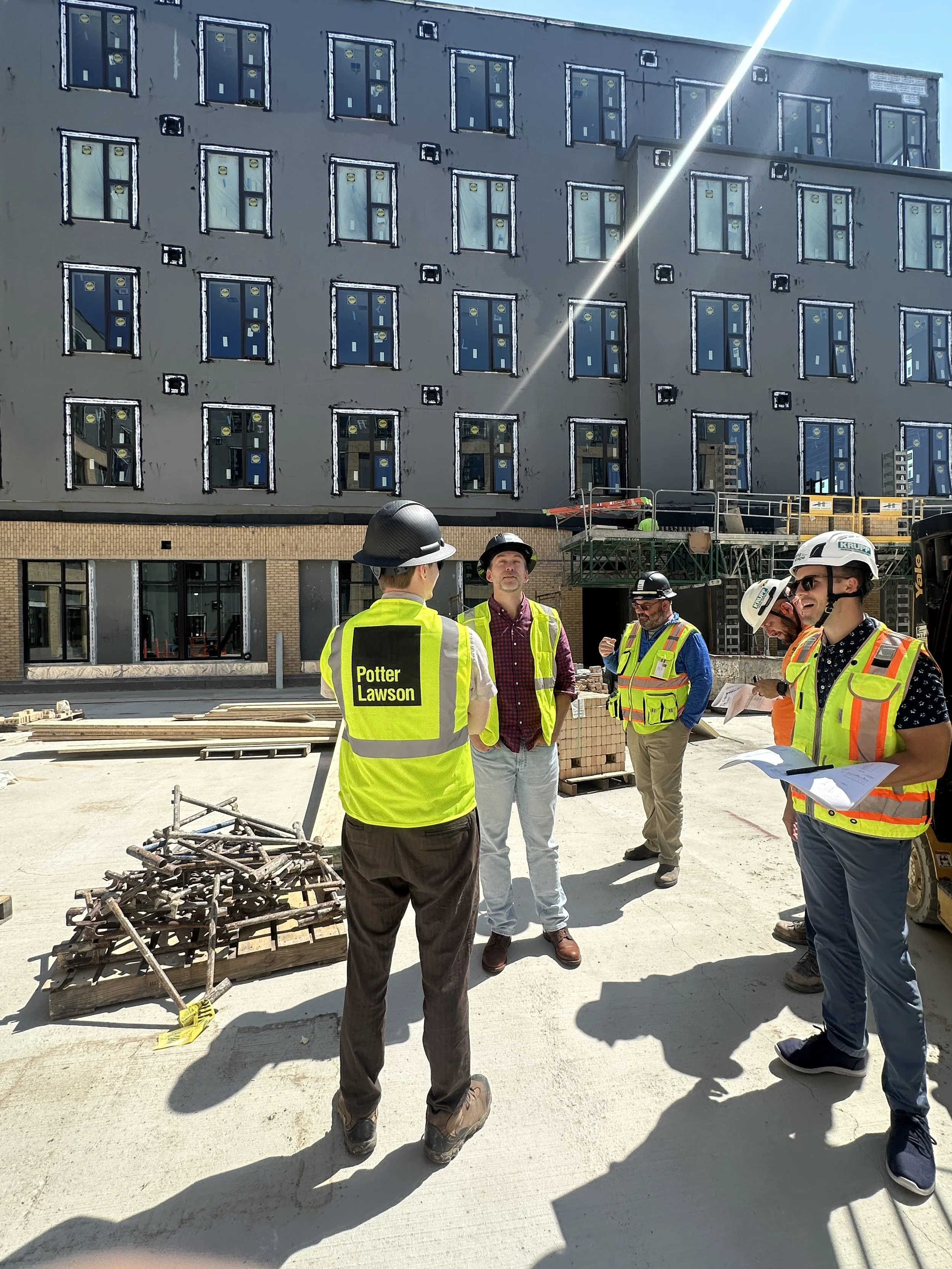 08.25.2026 - Members of the Taking Shape Team standing on the future courtyard outside The Kaleidoscope.