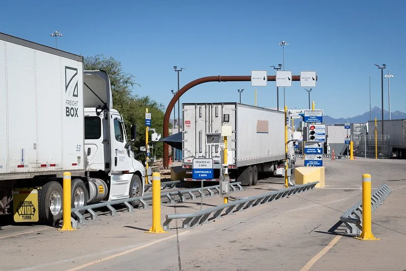 Línea de camiones siendo inspeccionados en la aduana por CBP
