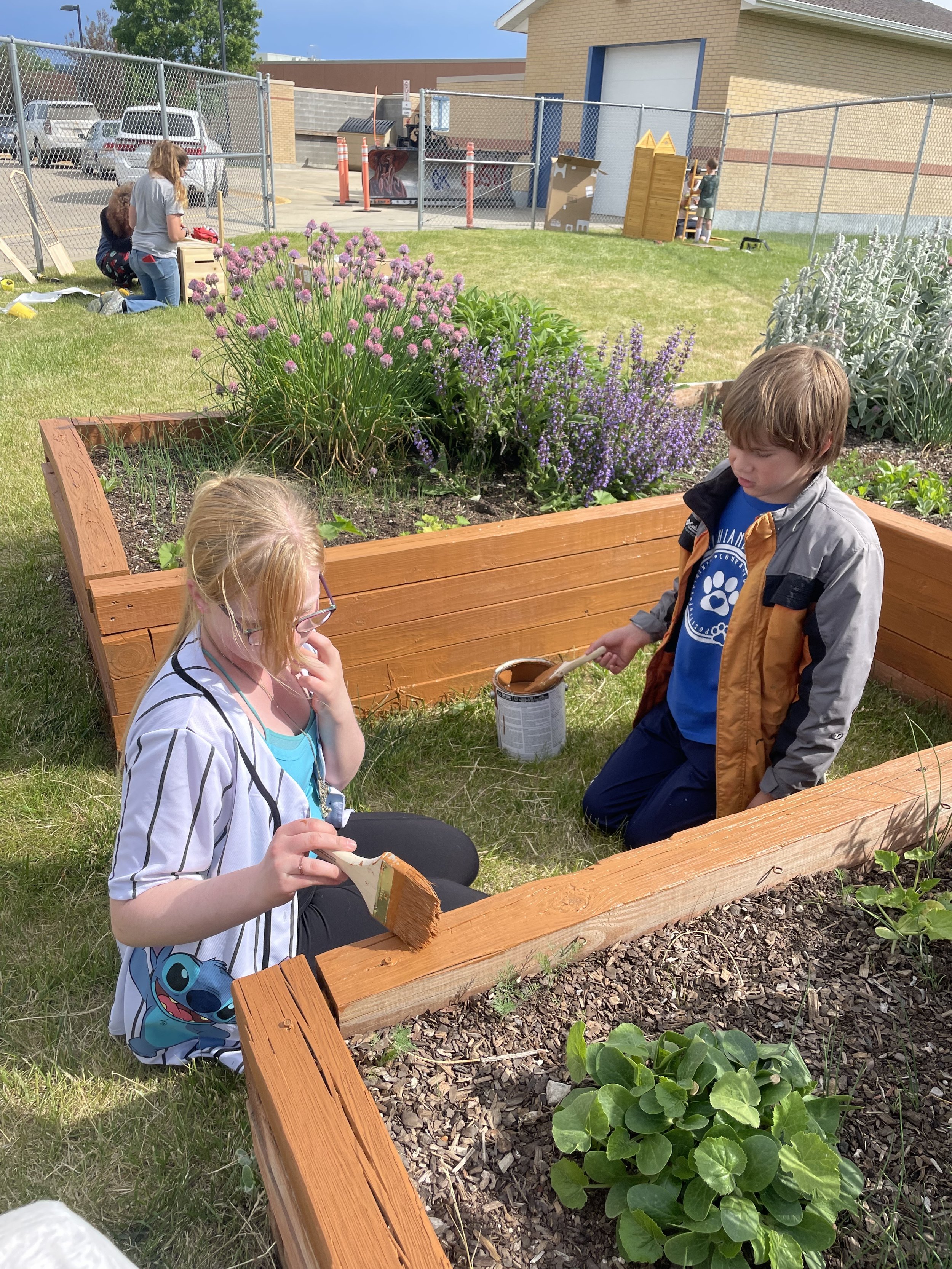 Students painting the garden bed.