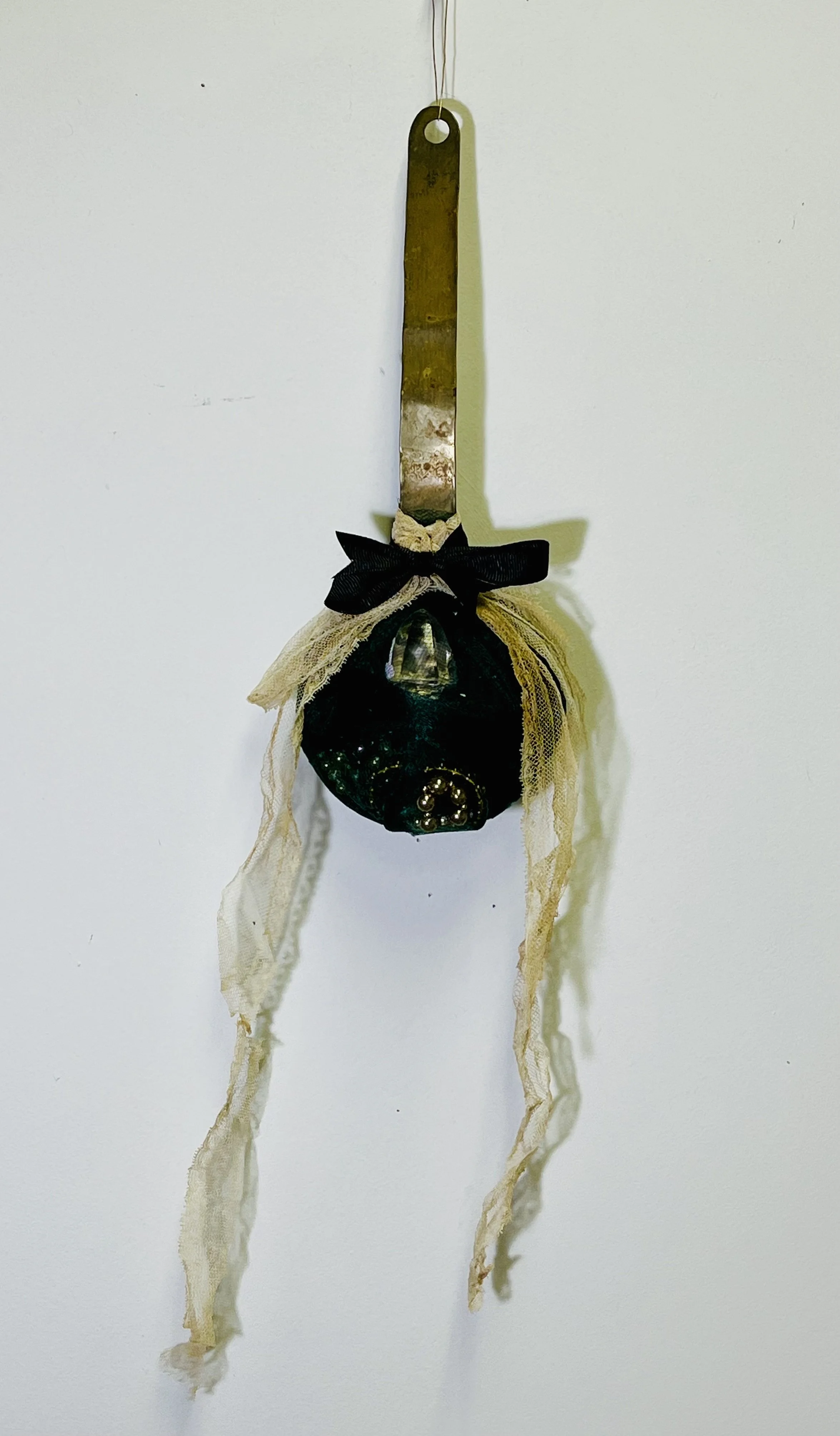 "GLASS in the NEST", brass ladle, strands of pearls, glass stopper, tulle. 24 X 6 X 6 inches