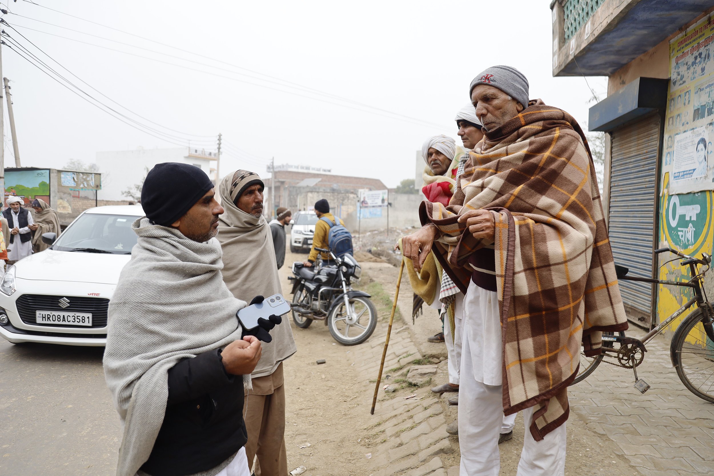  Jassi talks with friends on the streets of Harsola during a busy morning. Bikes, tractors and cars pulled through the village as farmers gathered to drink chai and talk agriculture before voting in a Primary Agriculture Cooperative Society election.
