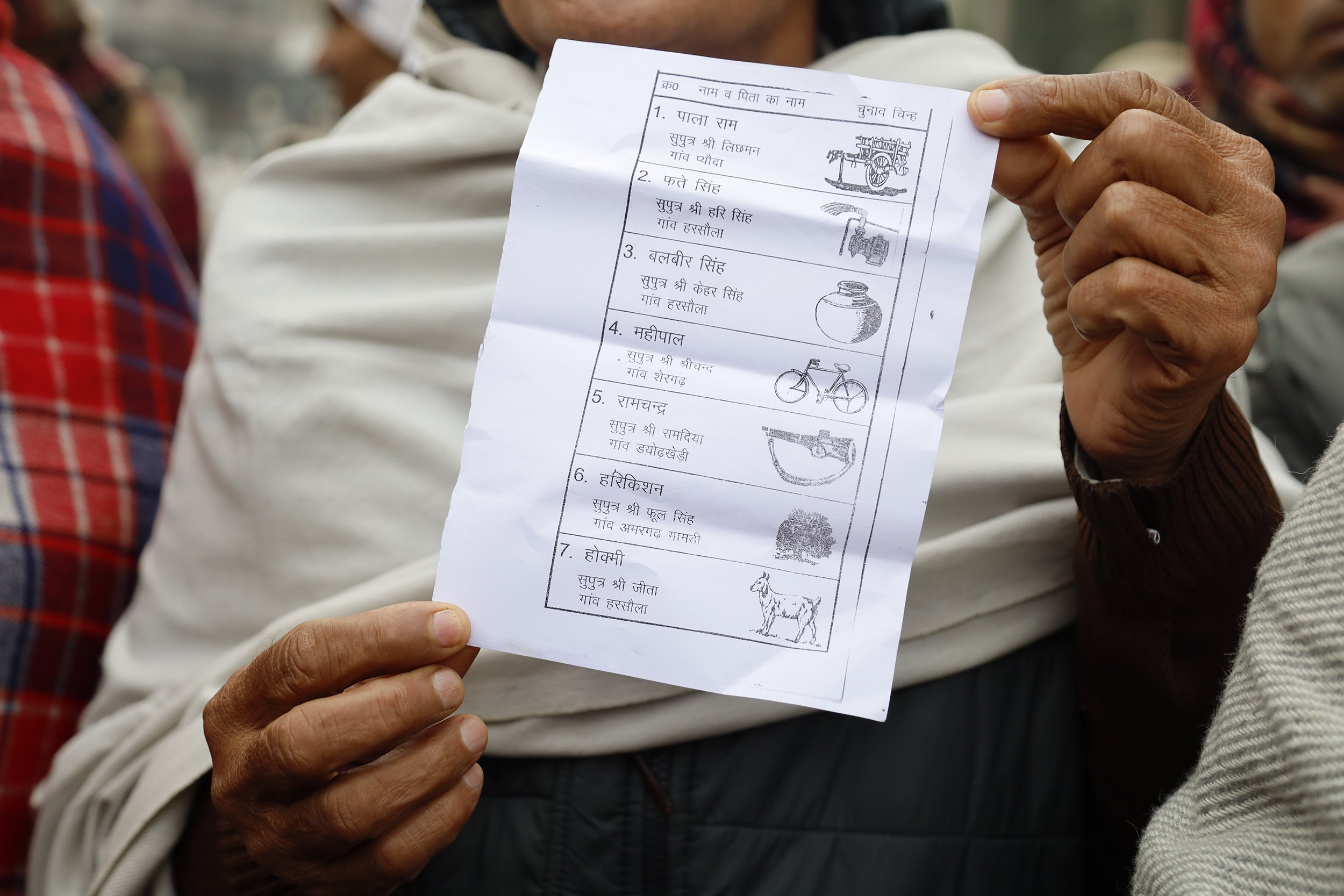  Hukmi Dhull holds up a ballot listing the names of farmers’ union candidates. | Photo by Sarah Bakeman 