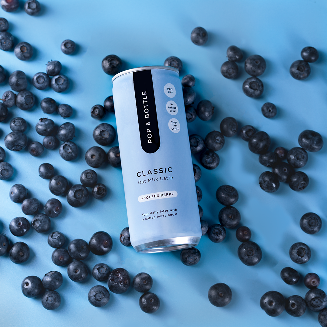 Clean product photography of oatmilk can with blueberries on blue background, Sacramento