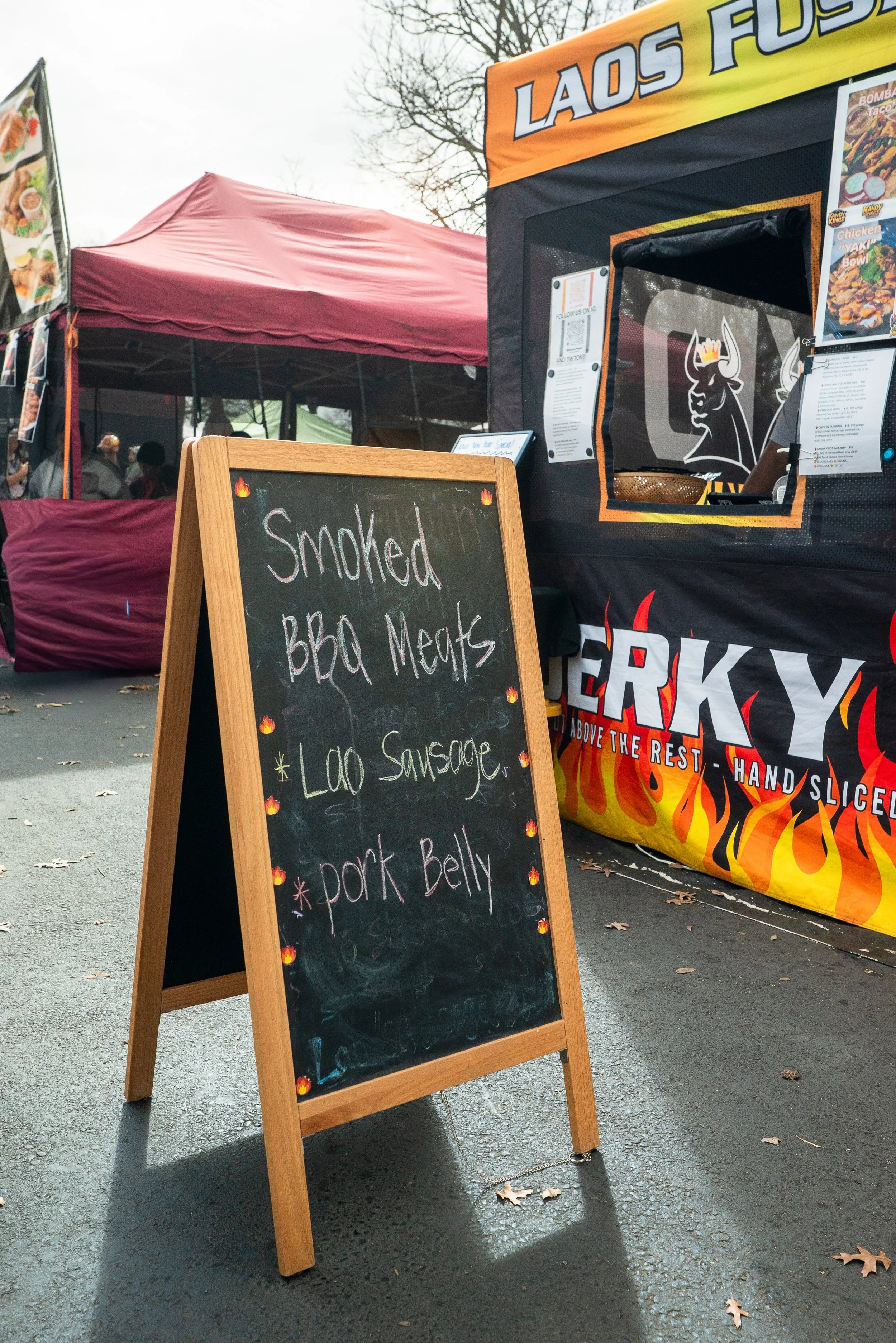  Chalkboard sign reading smoked BBQ meats, Lao sausage, and pork belly at the 2026 Elk Grove Tết Festival