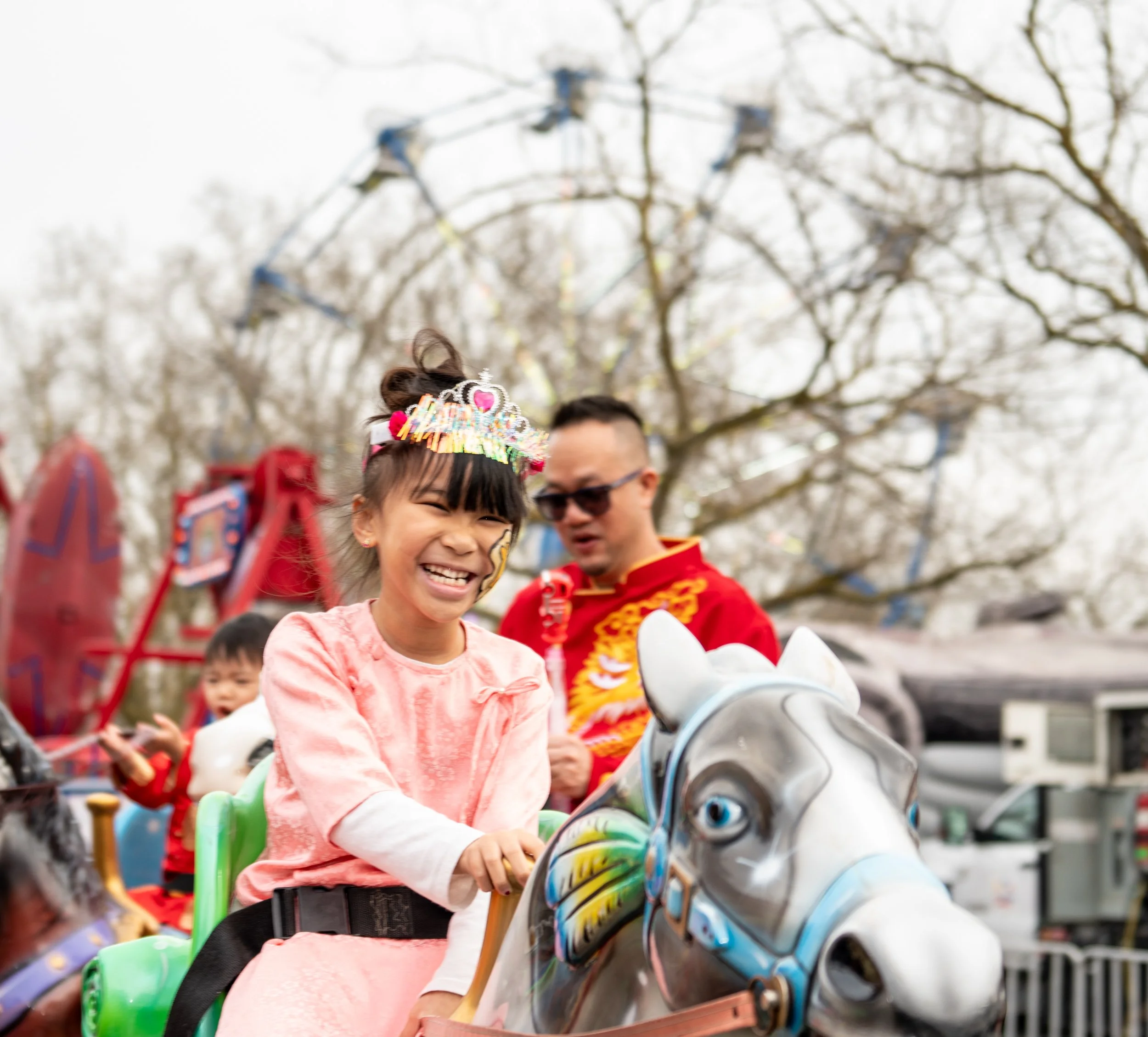 Young girl laughing on a carousel ride at the 2026 Elk Grove Lunar New Year Tết Festival