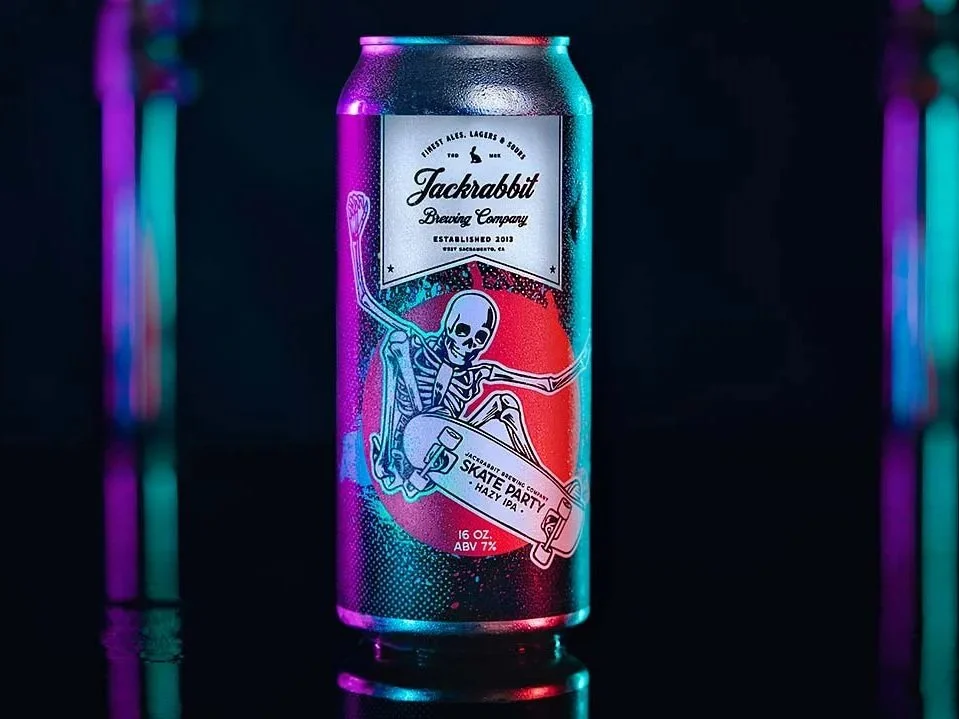 A colorful aluminum can of Jackrabbit Brewing Company with a skeleton skateboarding on a vibrant, neon-lit background.