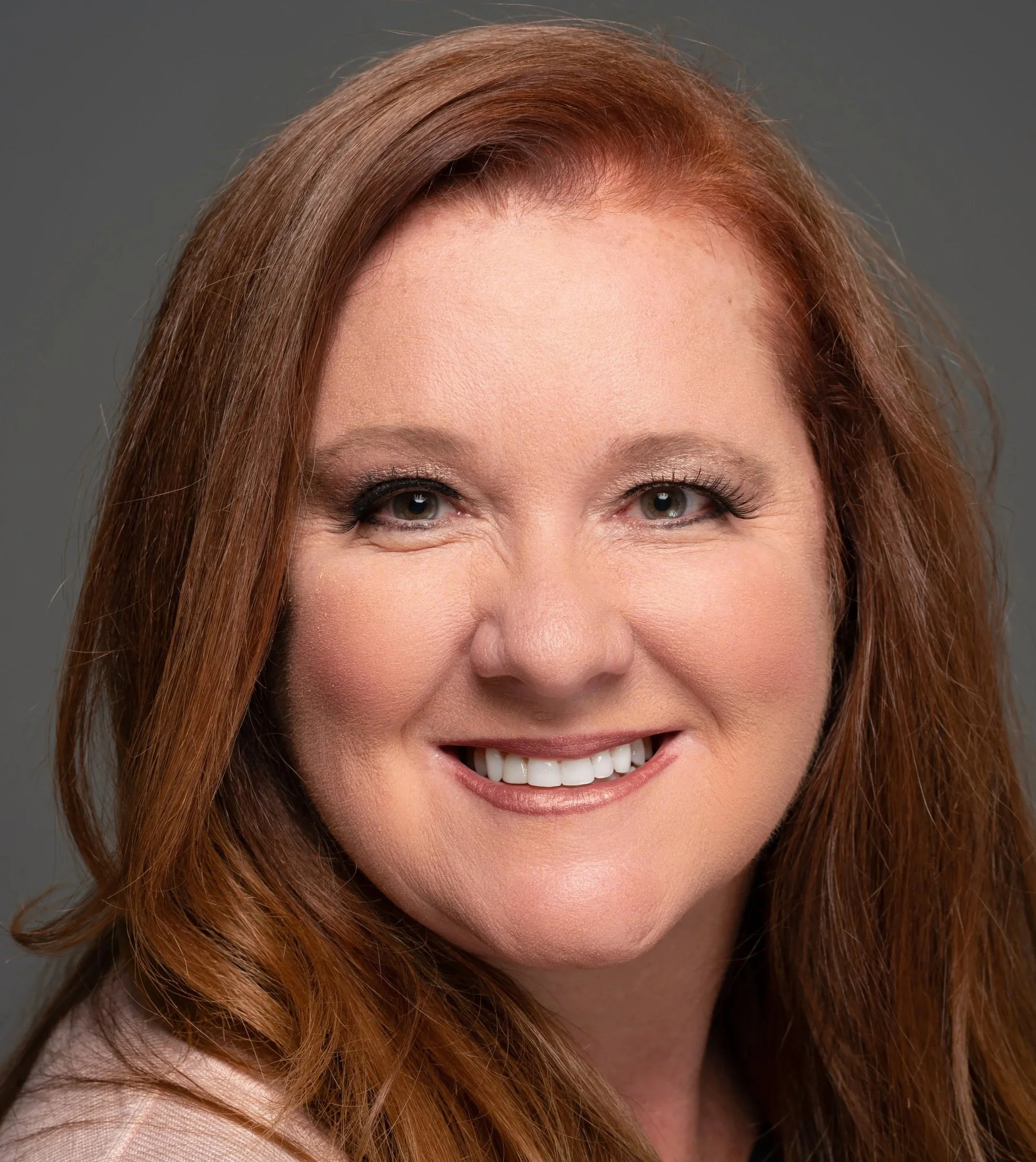 Corporate headshot of a professional woman in Sacramento with clean studio lighting