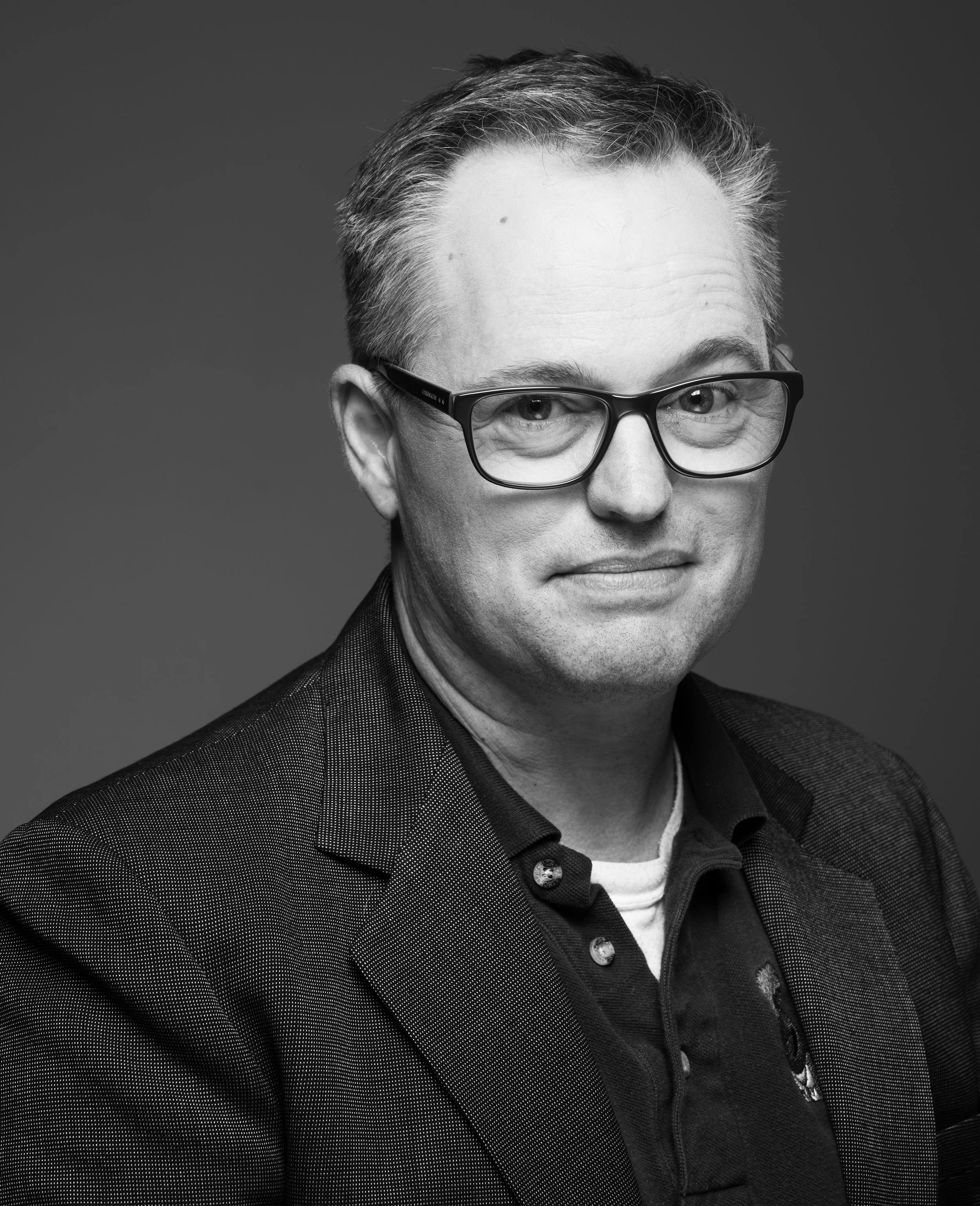 Black and white corporate headshot of a professional man with glasses in Sacramento