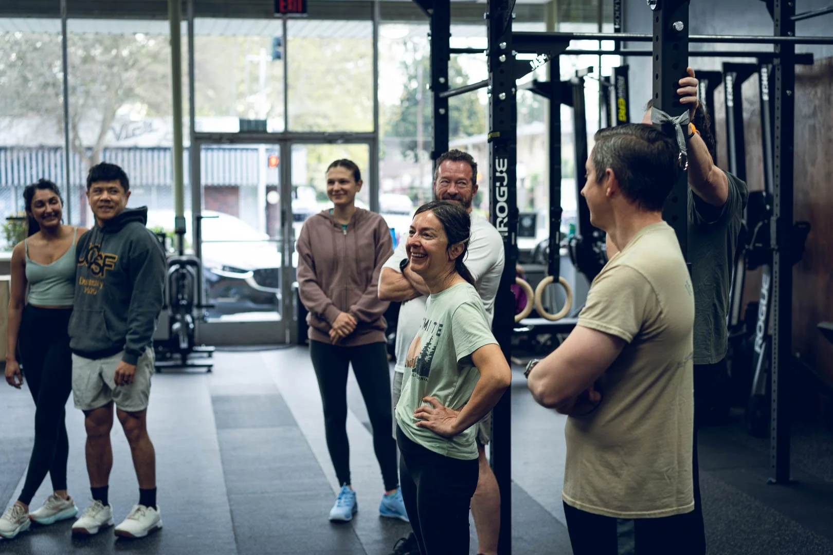 Woman smiling surrounded by others in a gym