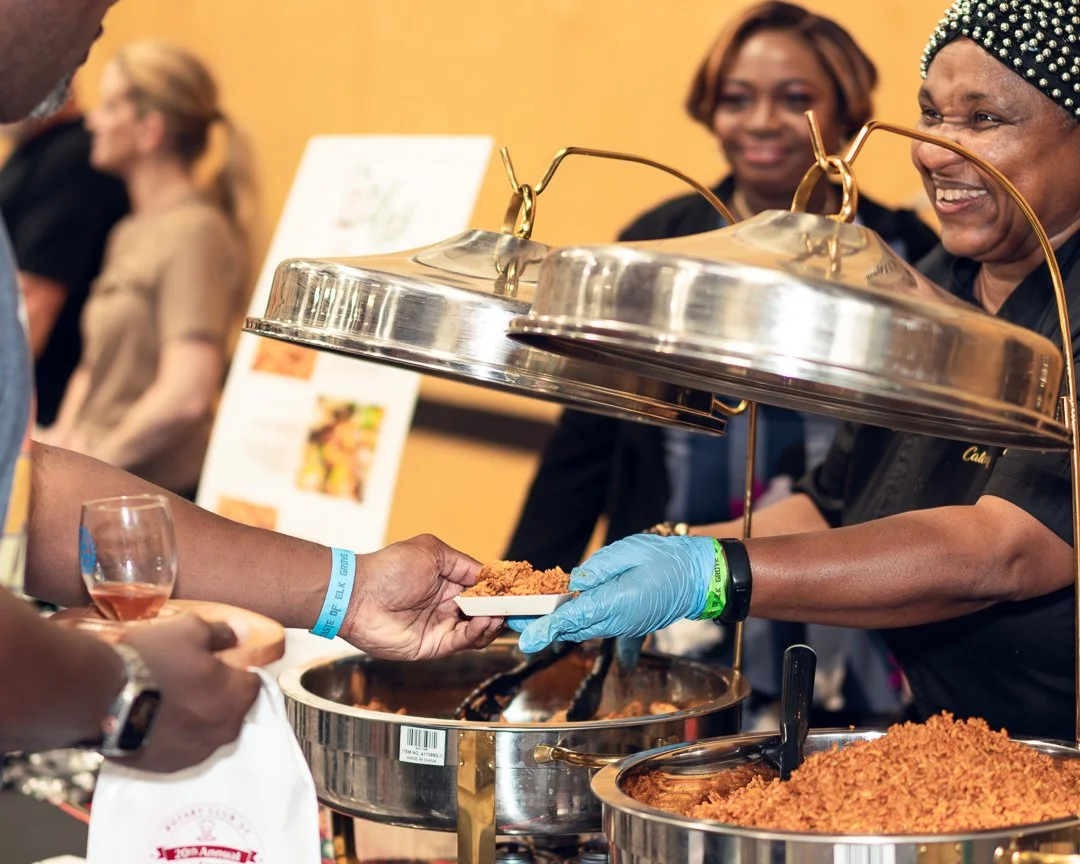 Lilian handing a serving of Nigerian food to a guest at the Taste of Elk Grove event