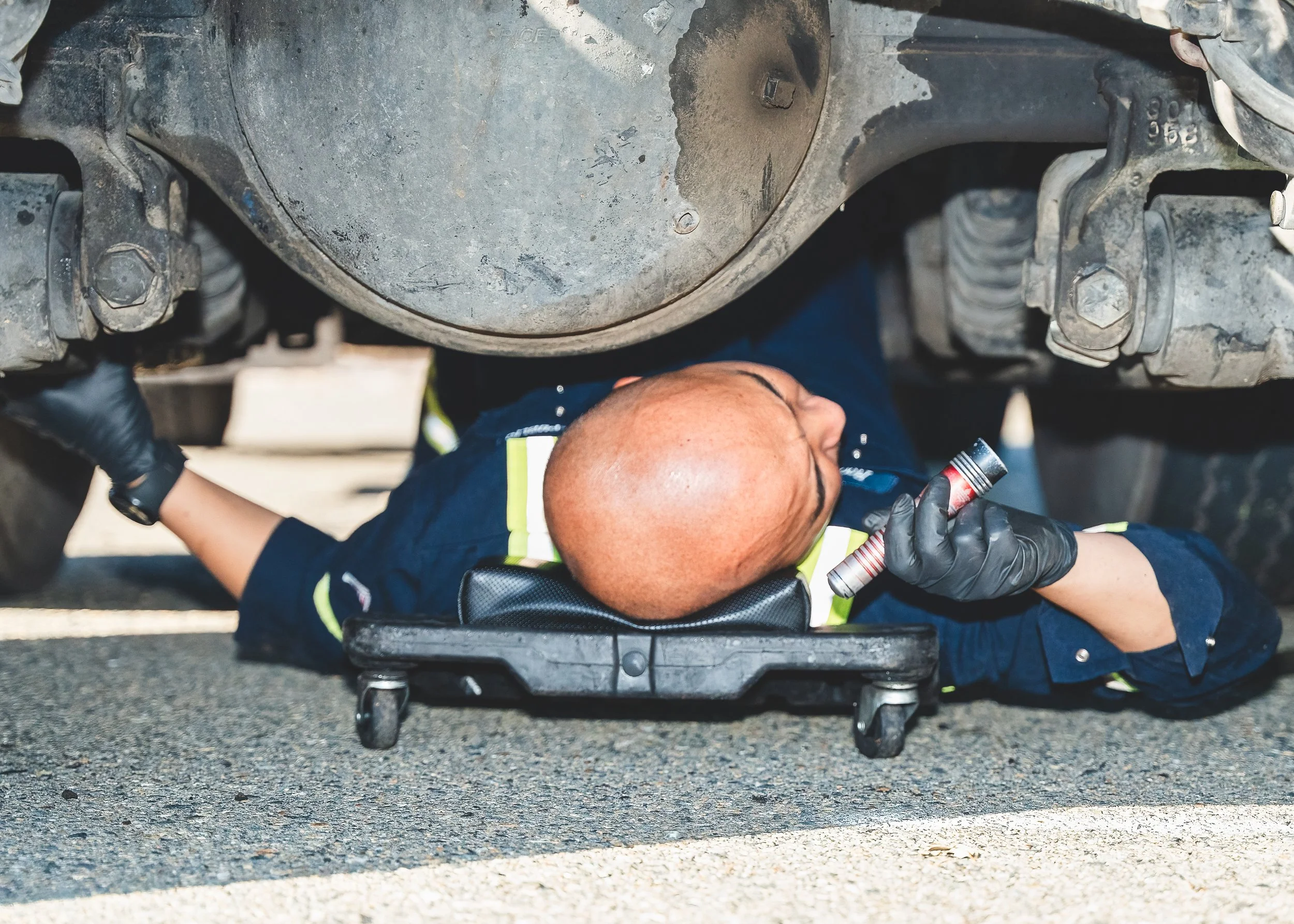 Close-up of technician performing maintenance under an industrial truck
