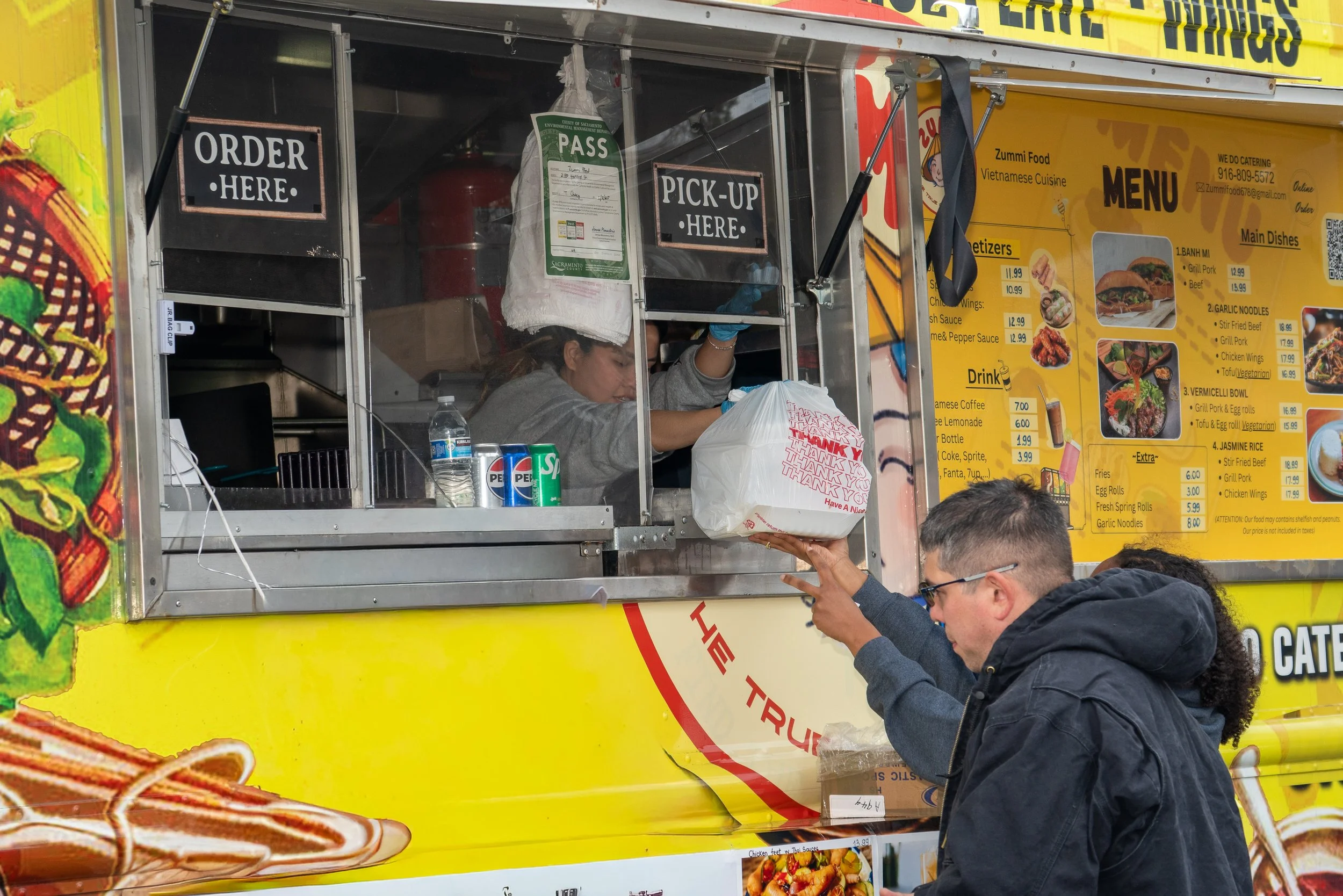 Customer receiving order from a Vietnamese food truck vendor at the 2026 Elk Grove Tết Festival