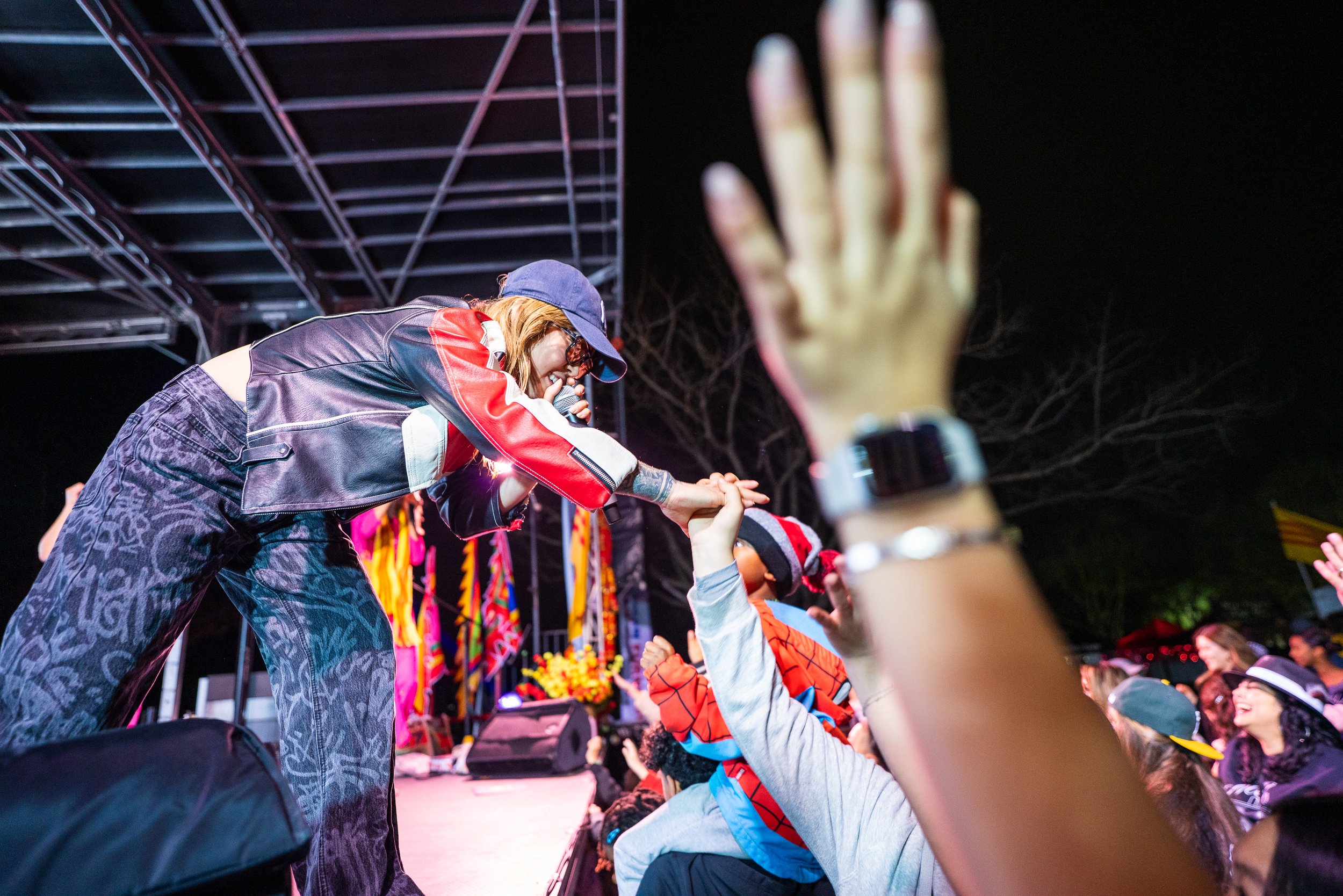 Performer reaching into the crowd at night at the 2026 Elk Grove Tết Festival