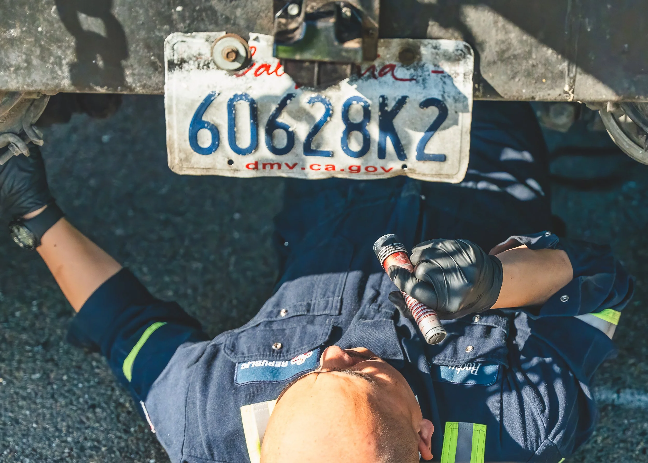 Overhead view of technician working beneath a vehicle during maintenance