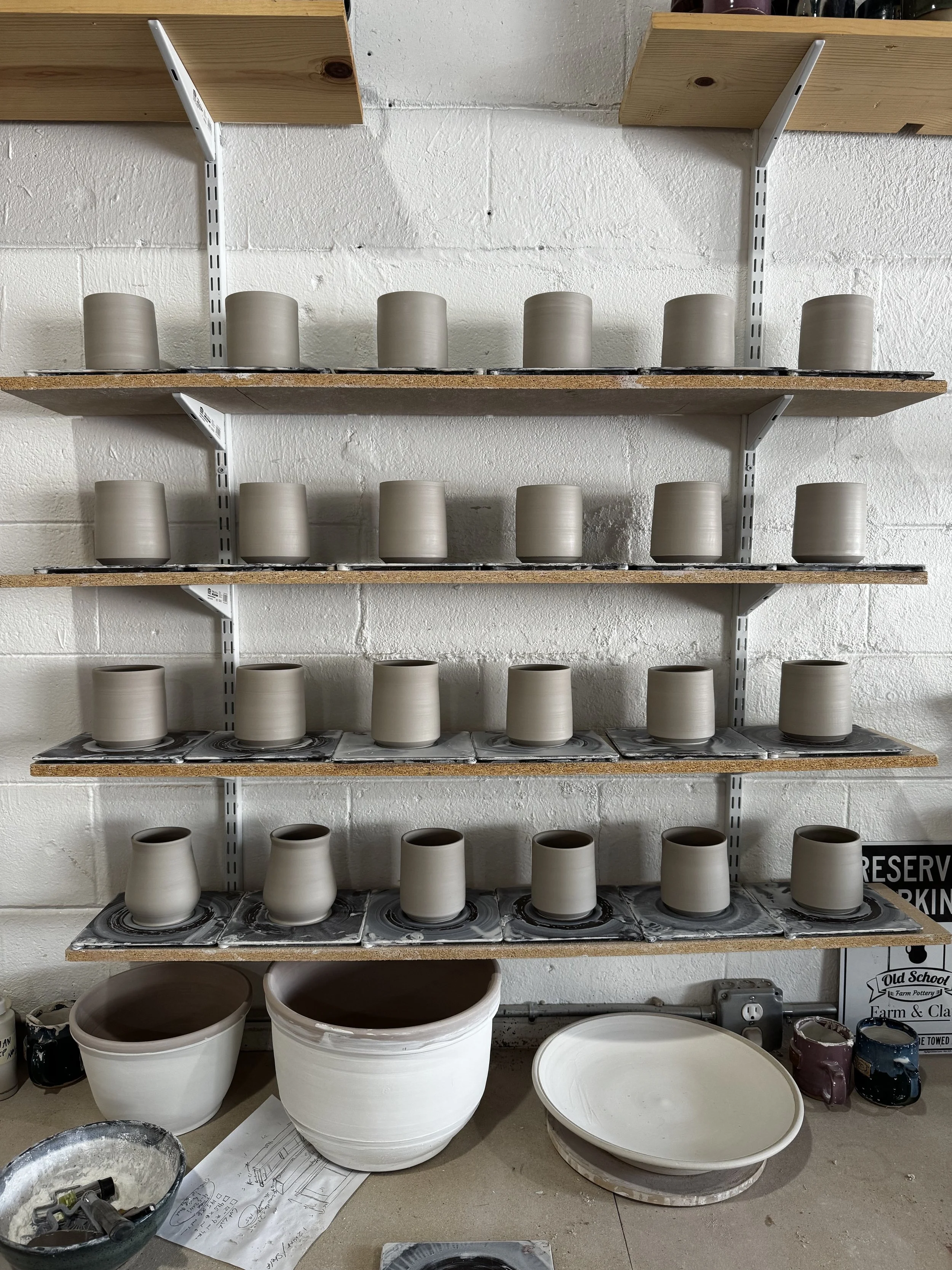 Shelves of mugs drying on a shelf at Old School Farm Pottery, a nonprofit Nashville pottery