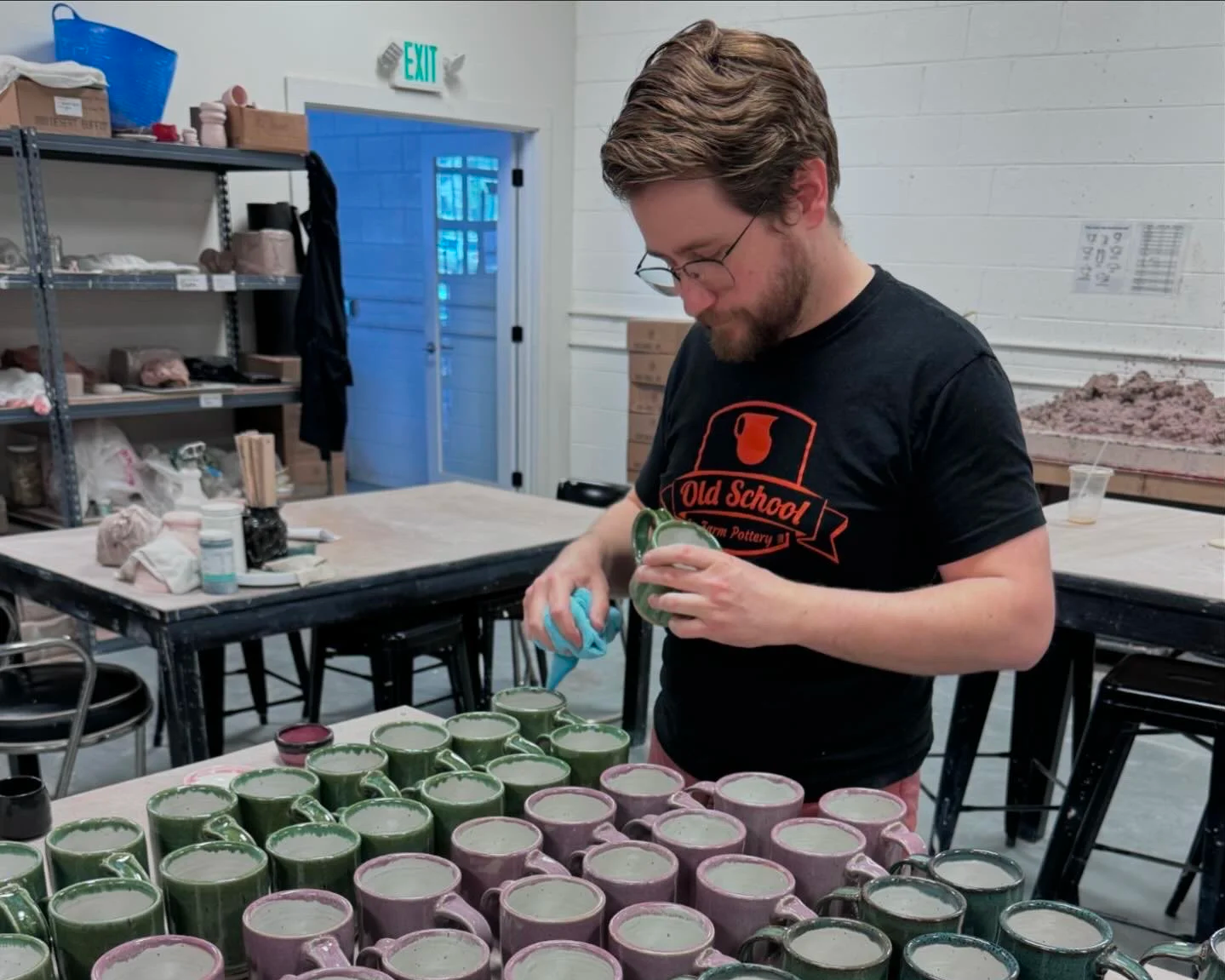 Brad cleaning production mugs at Old School Farm Pottery, a nonprofit Nashville Pottery