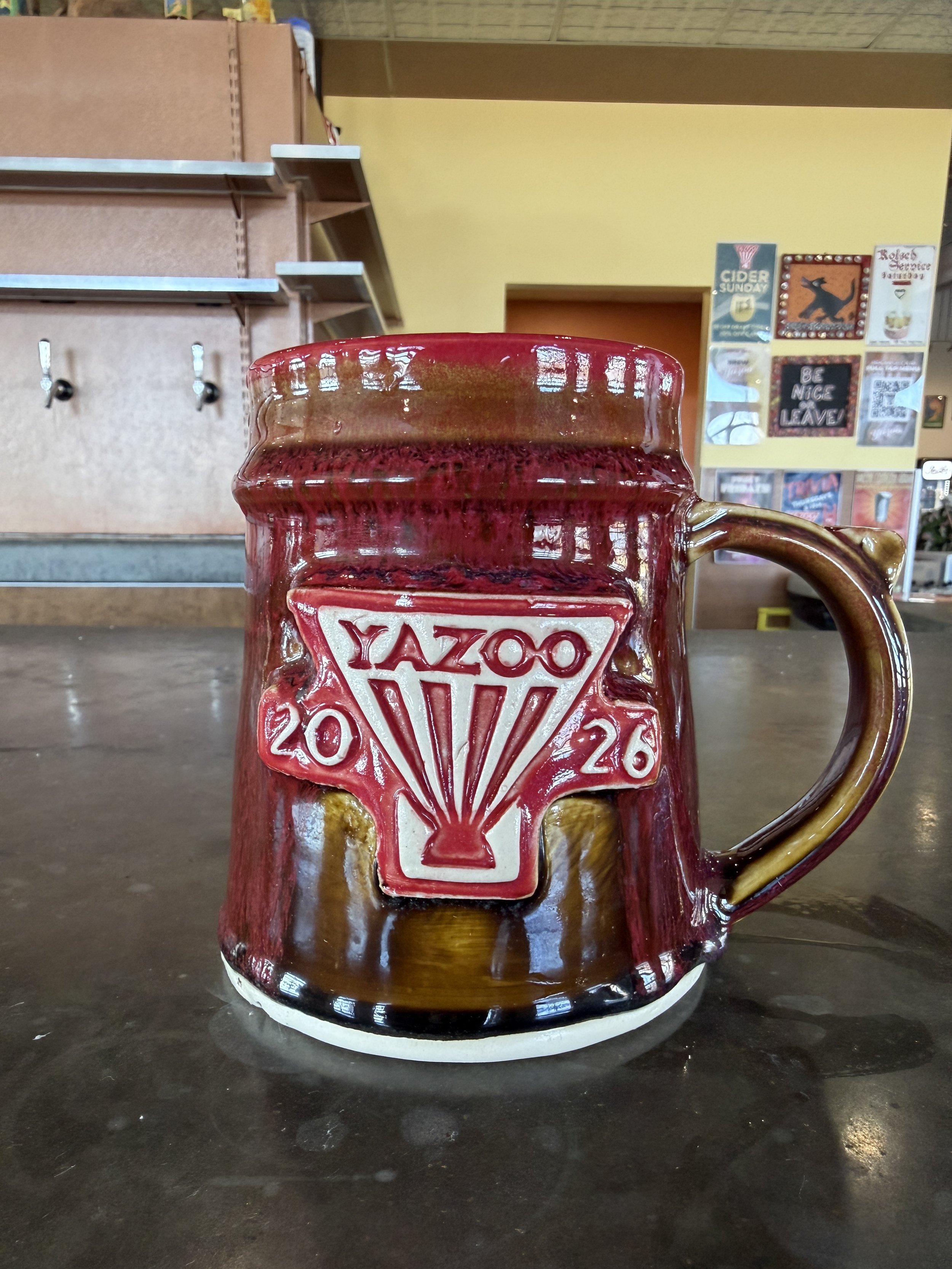 A completed Yazoo 2026 Mug Club Mug. Glazed with a custom red and tenmoku glaze. Made at Old School Farm Pottery, a nonprofit Nashville Pottery.
