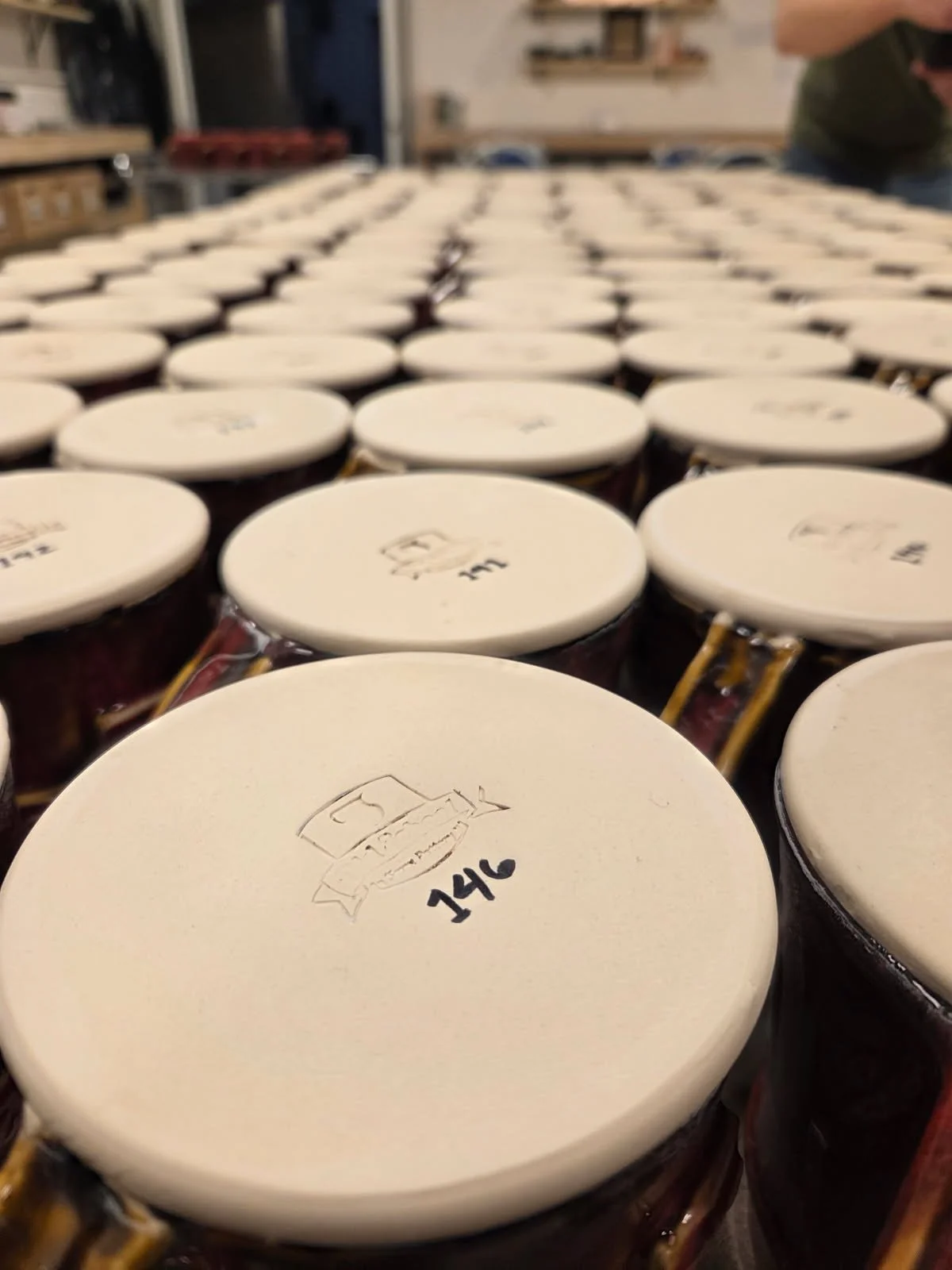 The bottoms of custom mugs with their numbers displayed. Made at Old School Farm Pottery, a nonprofit Nashville Pottery.
