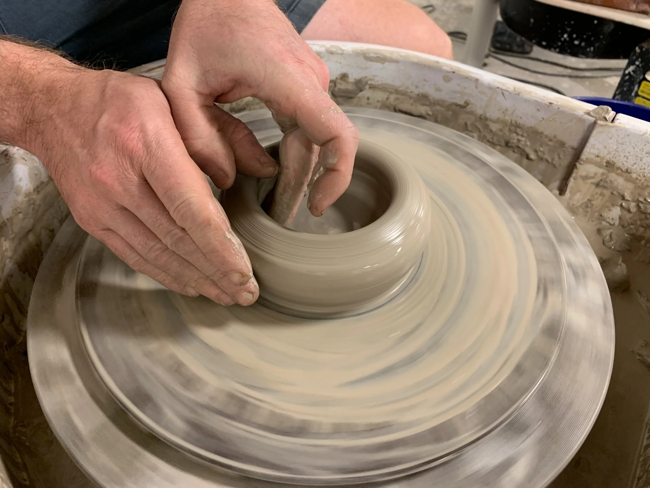 Hands forming a pot on a potter's wheel. At Old School Farm Pottery, a nonprofit Nashville pottery