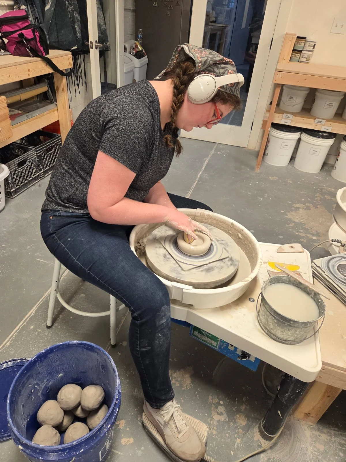 A potter, Sarah, throwing mug forms on a potter's wheel. Made at Old School Farm Pottery, a nonprofit Nashville Pottery