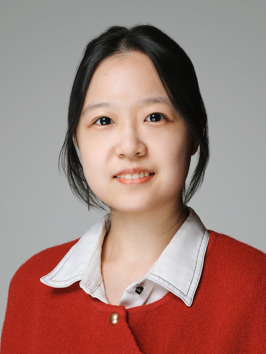 corporate-headshot-nyc-woman-red-cardigan-gray-background.jpg