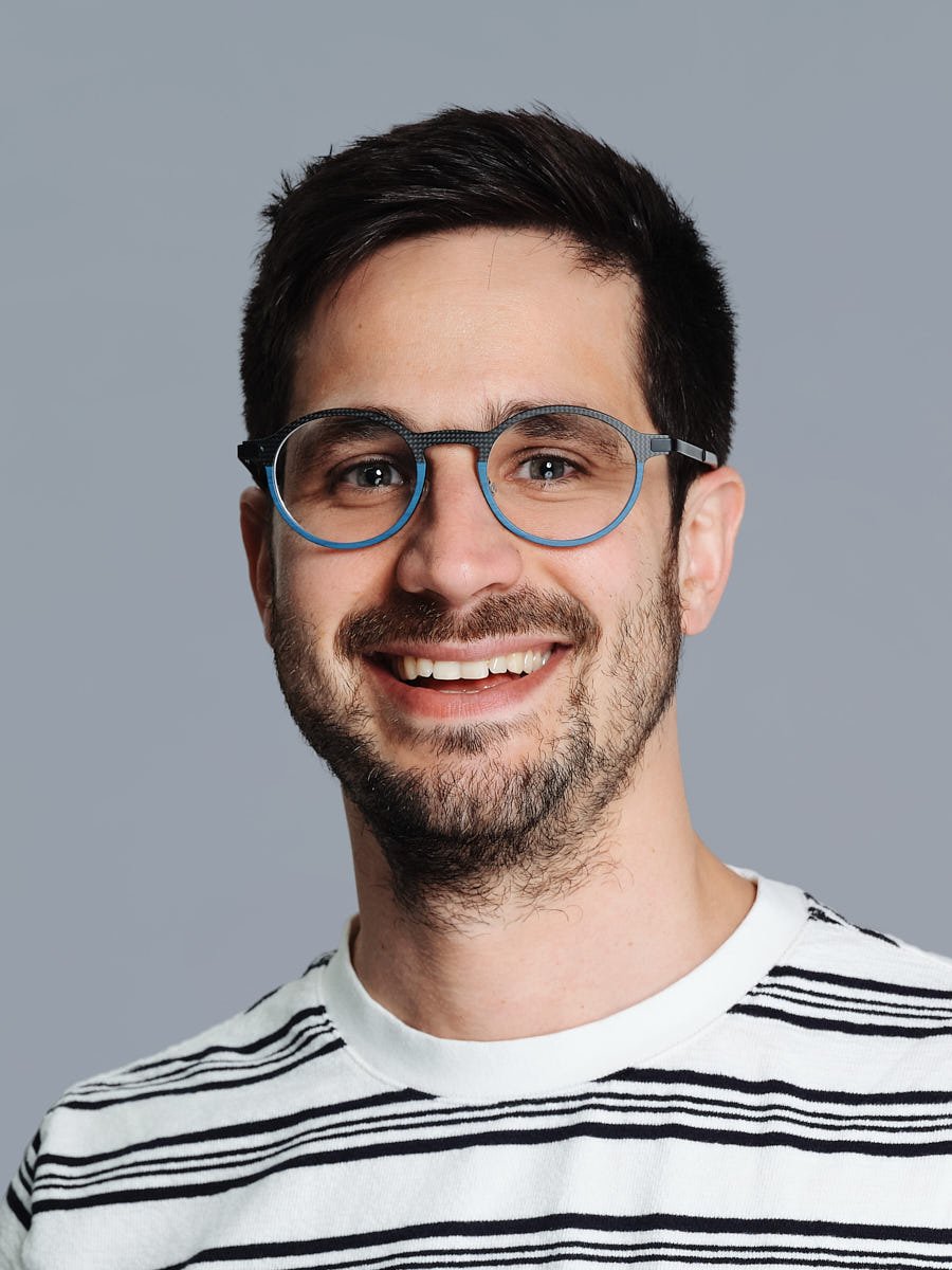 professional-headshot-nyc-man-striped-shirt-gray-background.jpg
