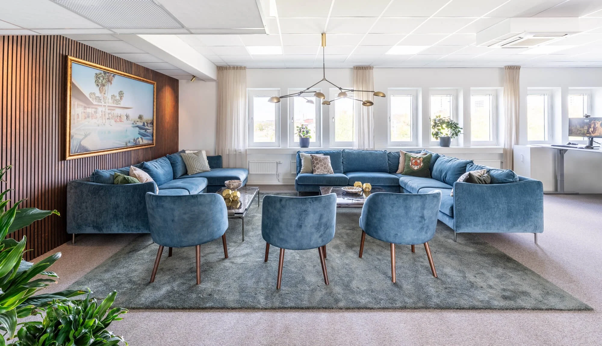 Kontorsinredning för Viatel i Stockholm med loungedel, blå soffor, valnötspanel och specialutvald konst.