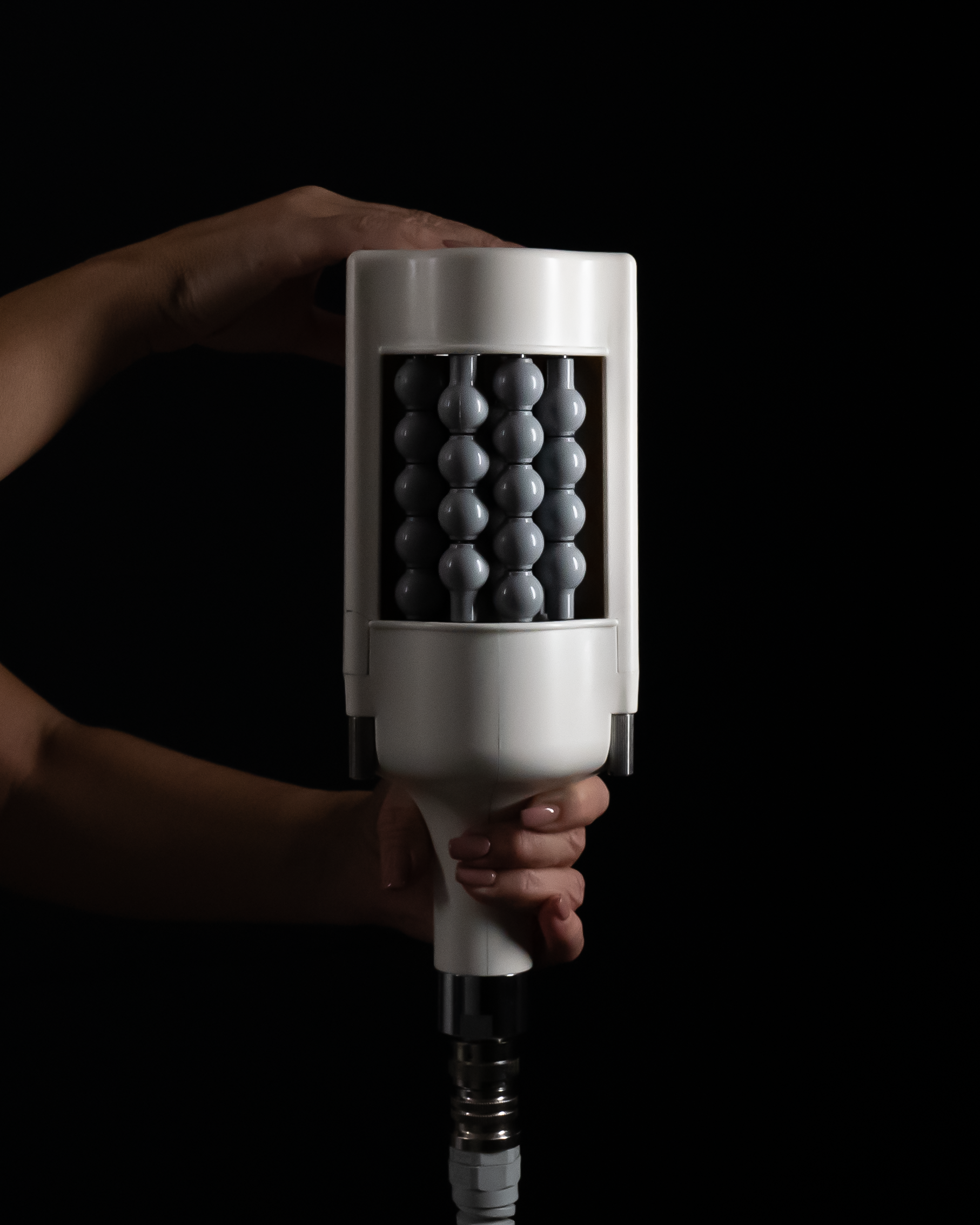 A person holding an abacus with gray beads in front of a black background.