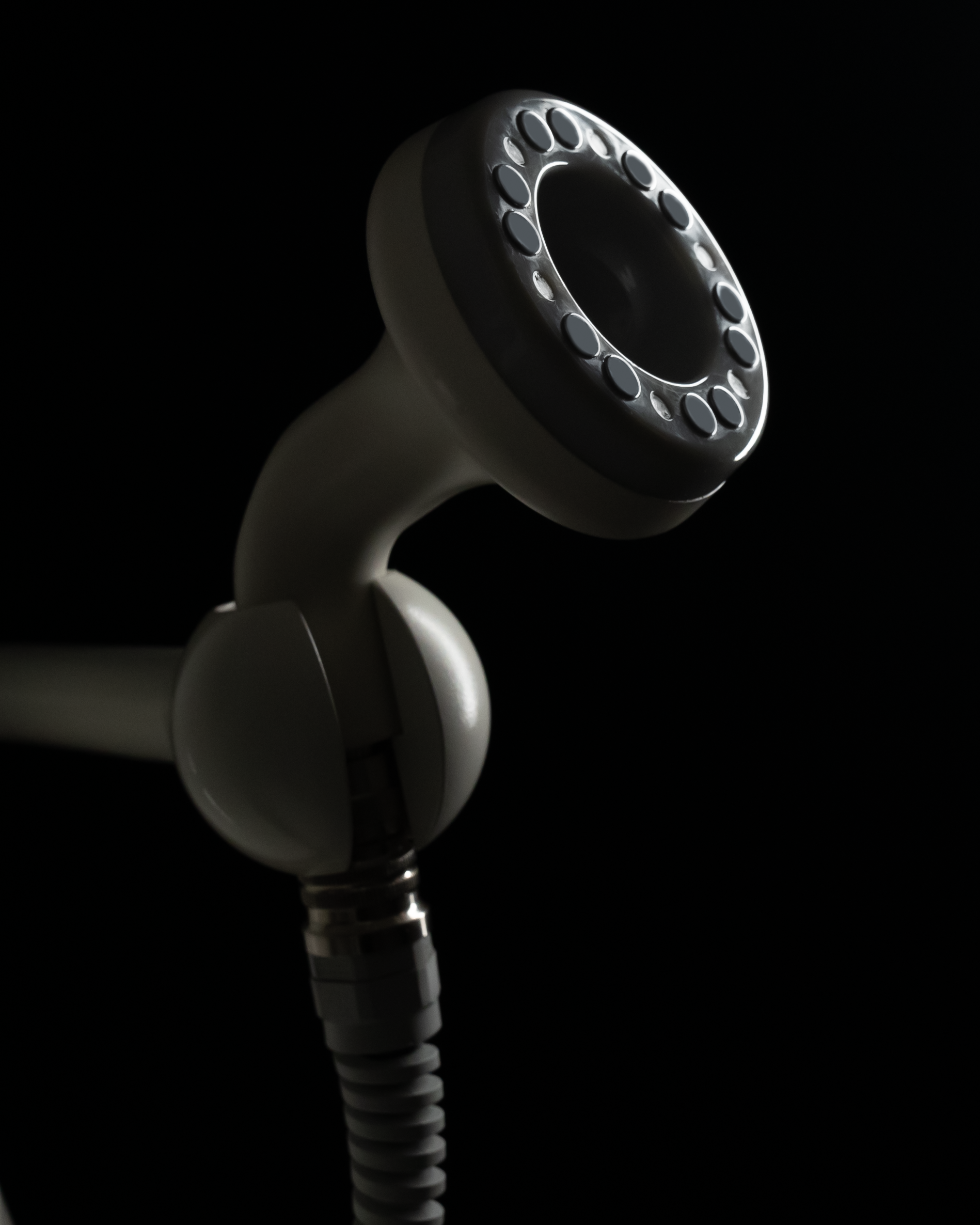 Medical or dental device with a circular, multi-lens or sensor arrangement on a dark background.