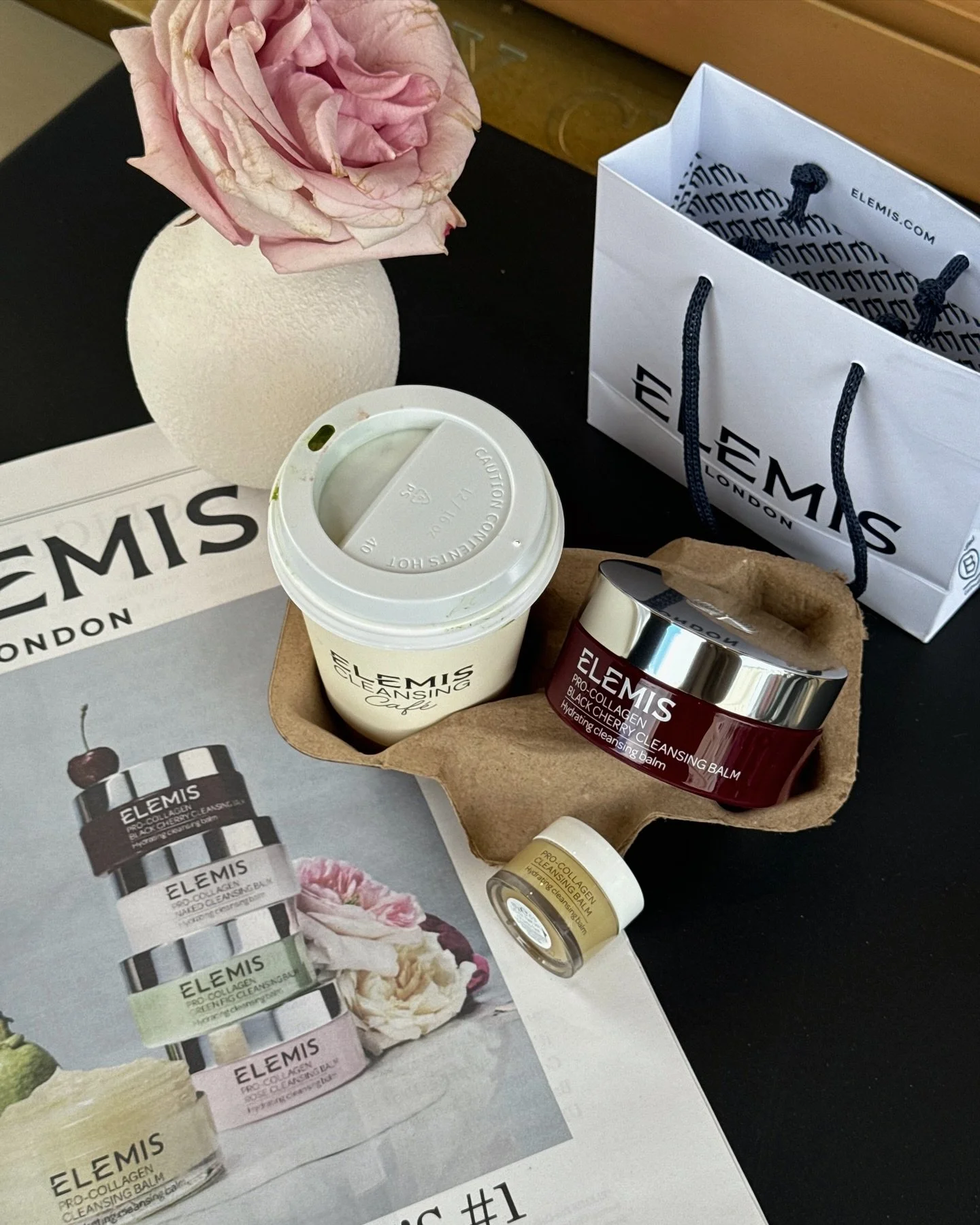 Product photography of a jar of Elemis pro-collagen cherry cleansing balm with a coffee cup, at the Elemis Cafe pop up in Notting Hill, London. Influencer brand event beauty skincare campaign photography by StudioTaggy.