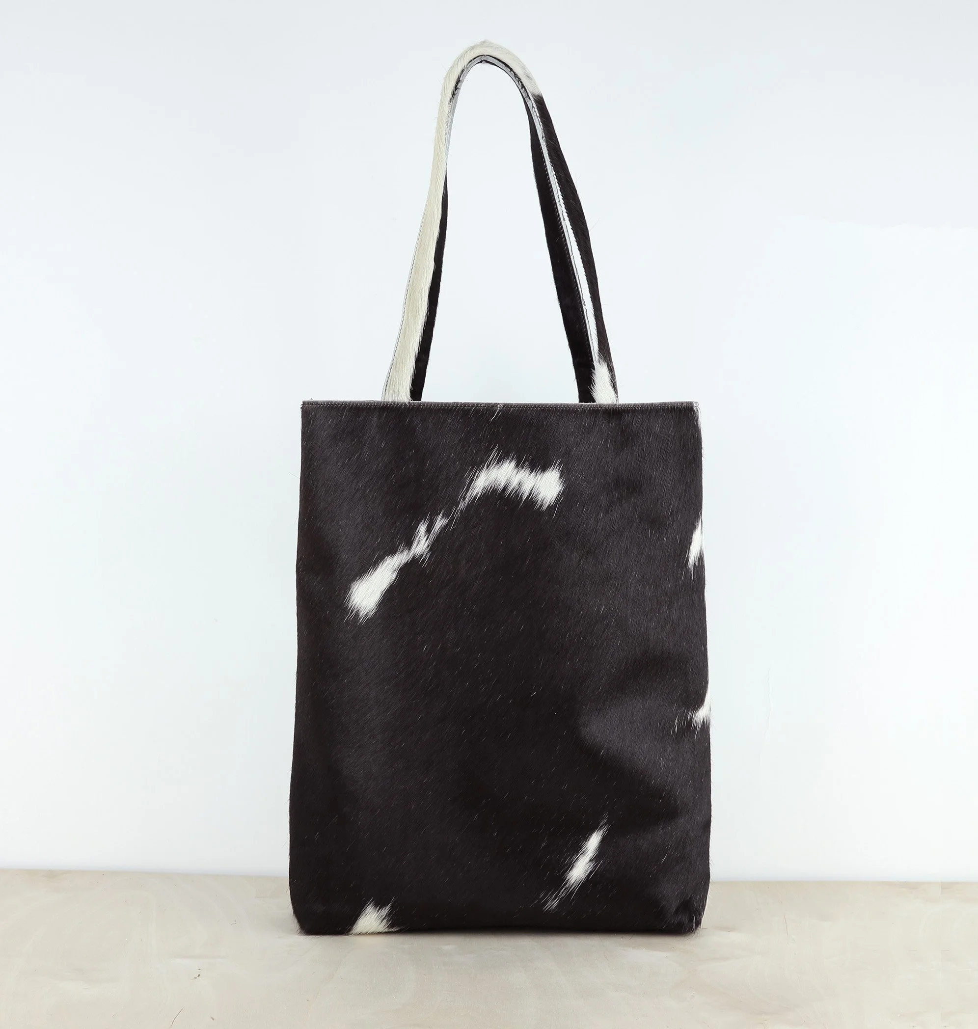 This classic CASE cowhide tote is made from sleek hair on hide cow leather and lined in black cotton.
