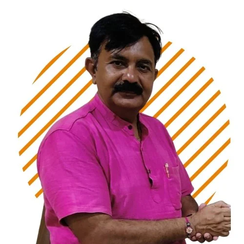 A man with black hair and a mustache wearing a pink traditional Indian kurta, standing with his arms crossed against a white background with orange diagonal lines.