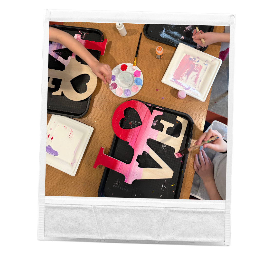 Photo of girls painting wooden LOVE signs with red and pink paint birthday party intimate teenagers