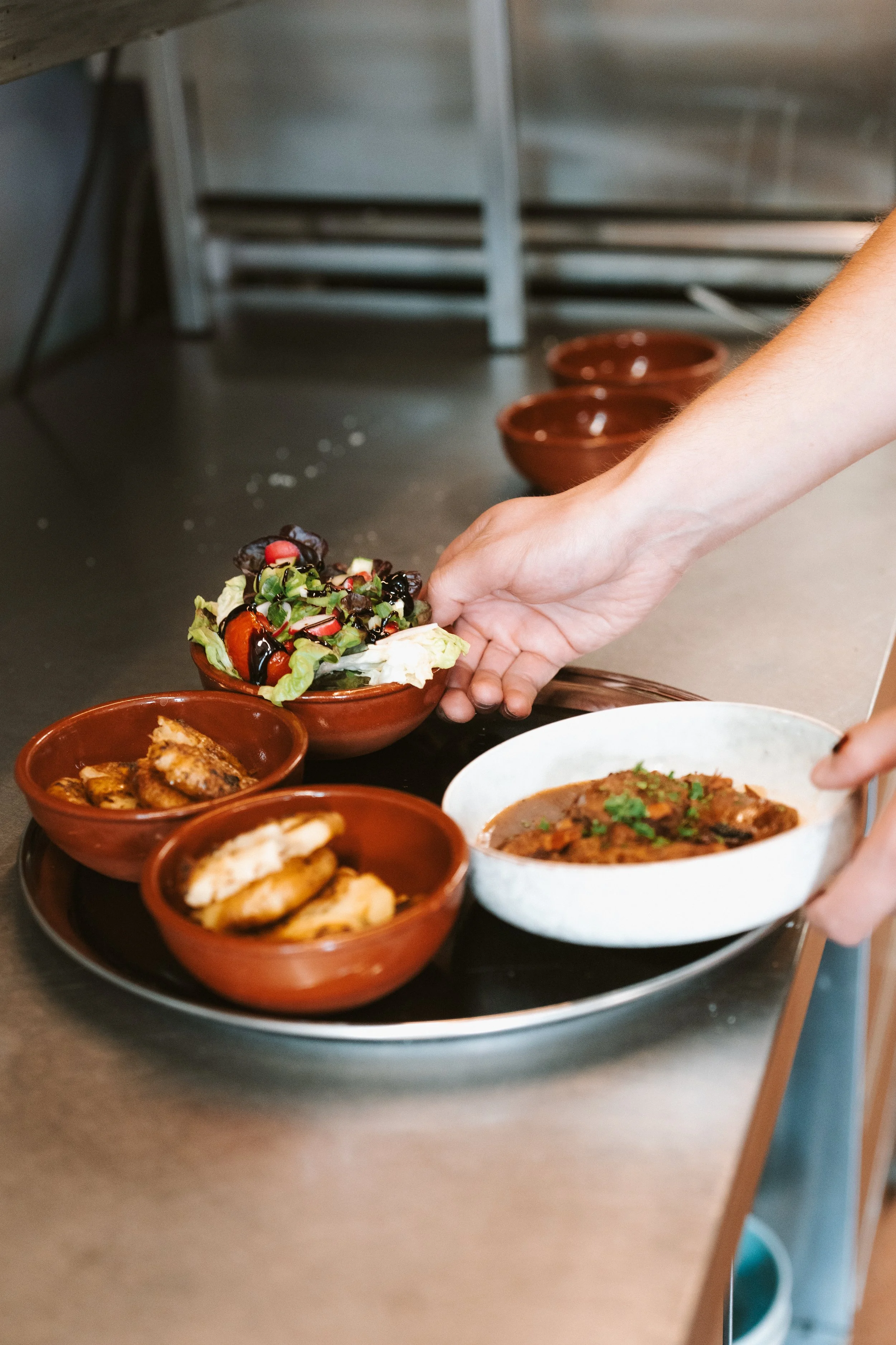 Diverse gerechten op een dienblad in een keuken.