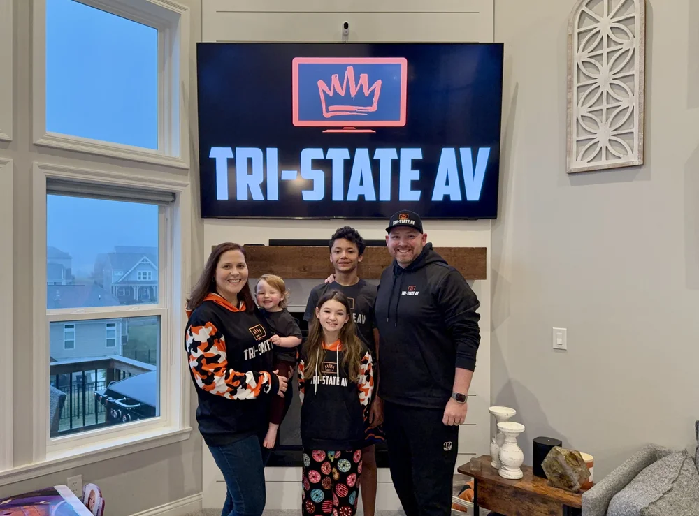 Matt King and his family in front of a TV showing the Tri-State AV logo