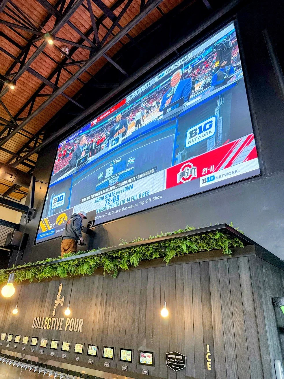Large LED video wall above a bar with live sports, installed by Tri-State AV