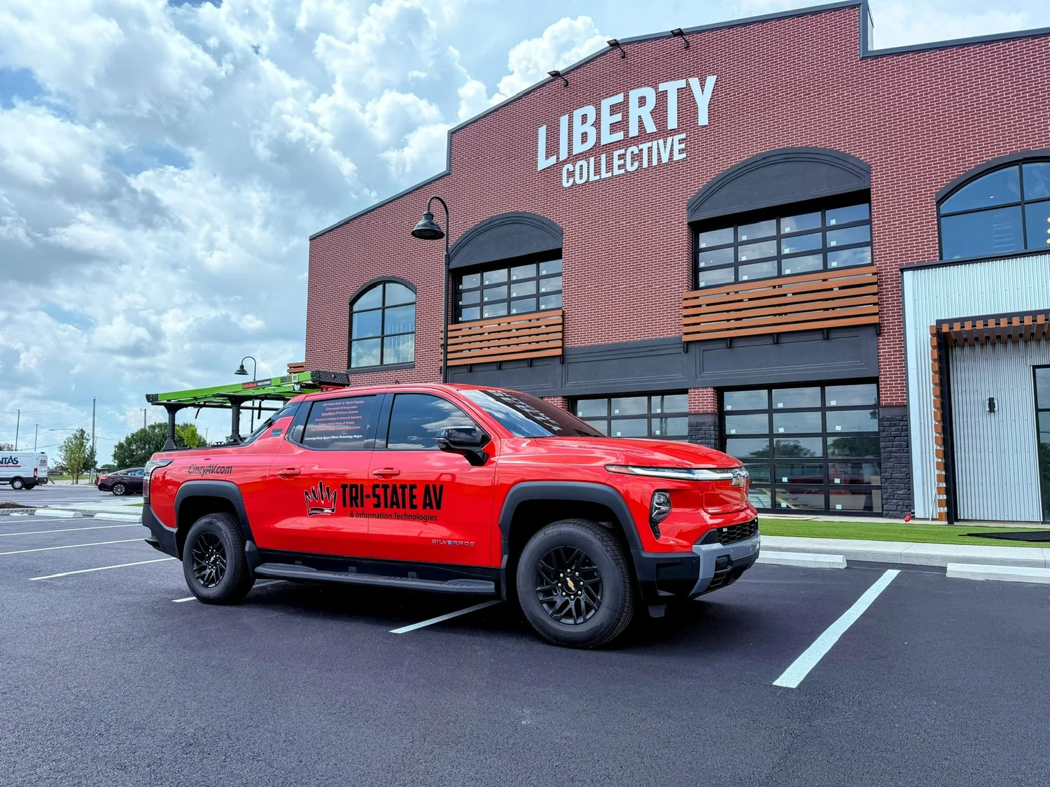 Red Tri-State AV pickup truck parked in front of Liberty Collective