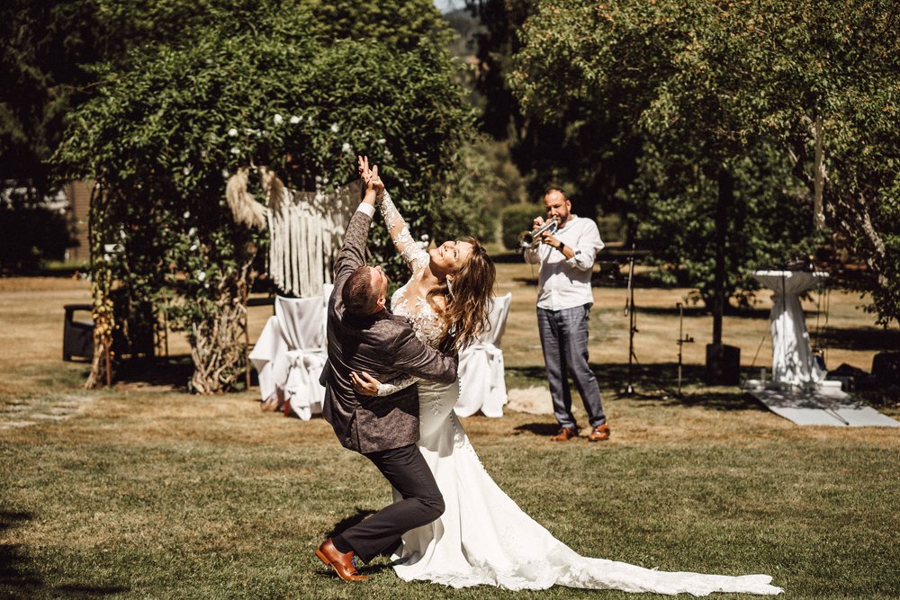 Brautpaar tanzt verrückt im Park zu Trompetenspiel by UhlArt Fotografie
