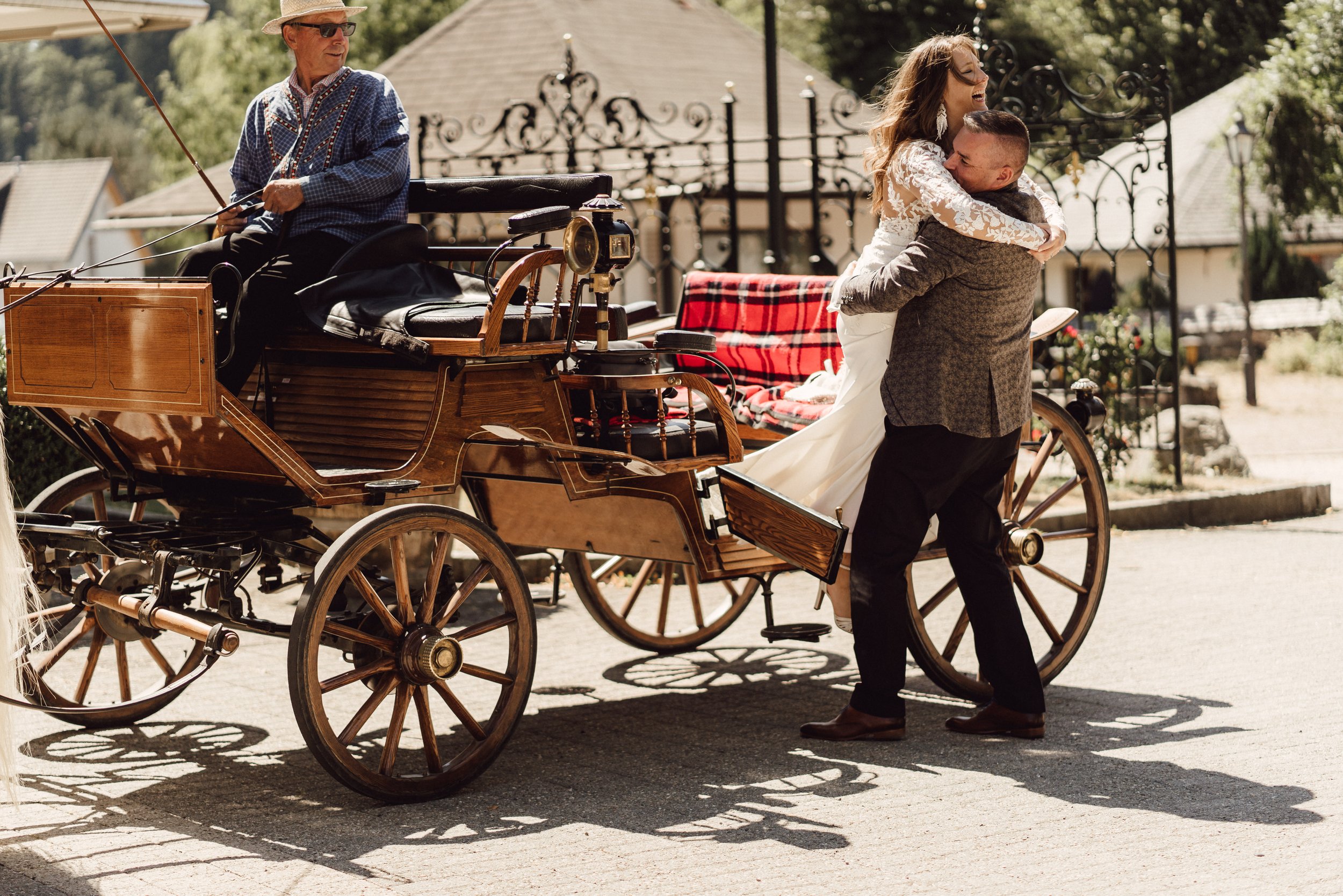 Bräutigam hebt Braut aus der alter Kutsche by UhlArt Fotografie
